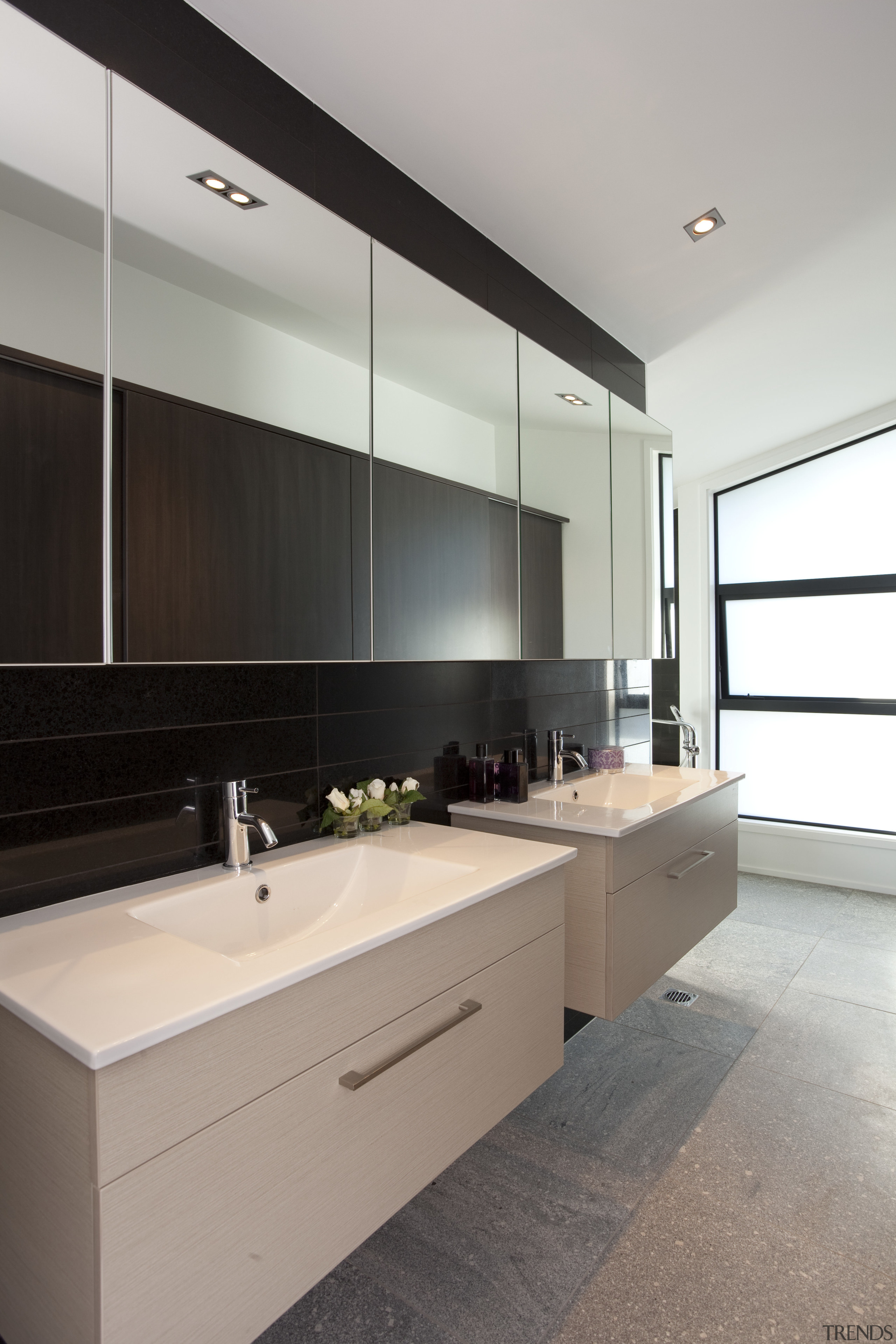 View of bathroom with cream twin vanities, row architecture, bathroom, cabinetry, countertop, interior design, kitchen, room, sink, gray