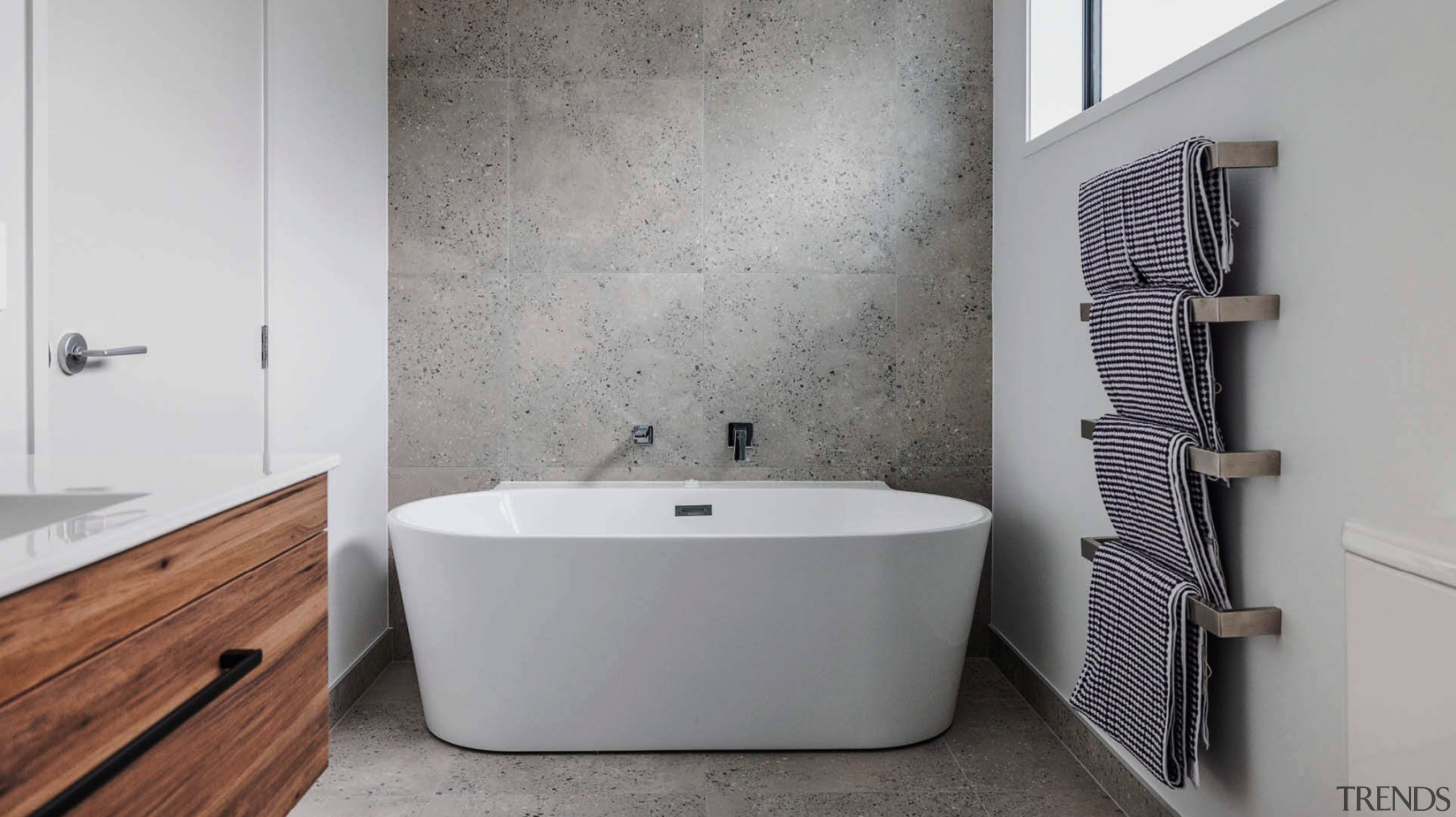 Main bathroom with chic, back-to-the-wall tub that offers 