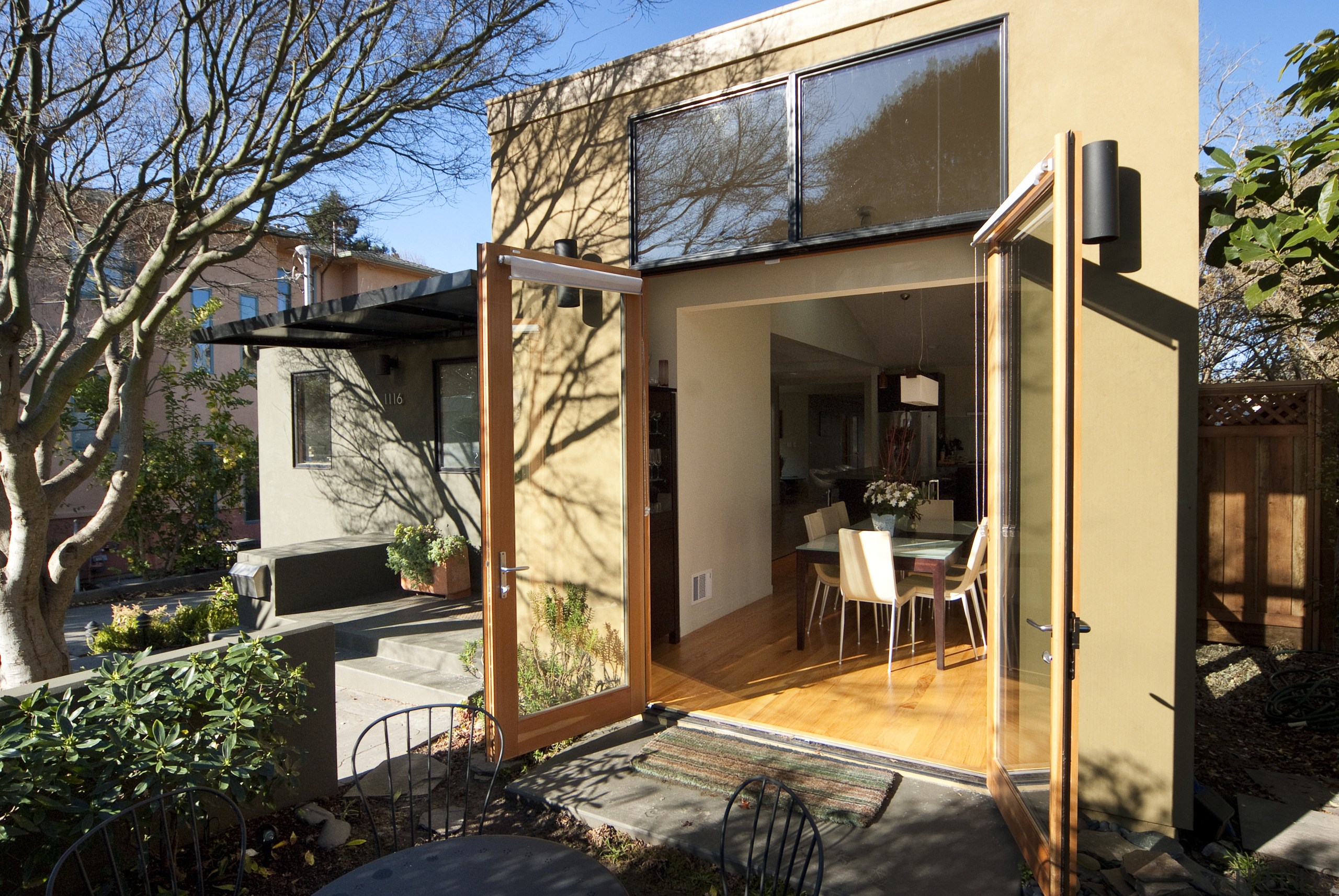 Dining room opening out to patio with landscaping. backyard, cottage, facade, home, house, outdoor structure, property, real estate, roof, shed, siding, window, black