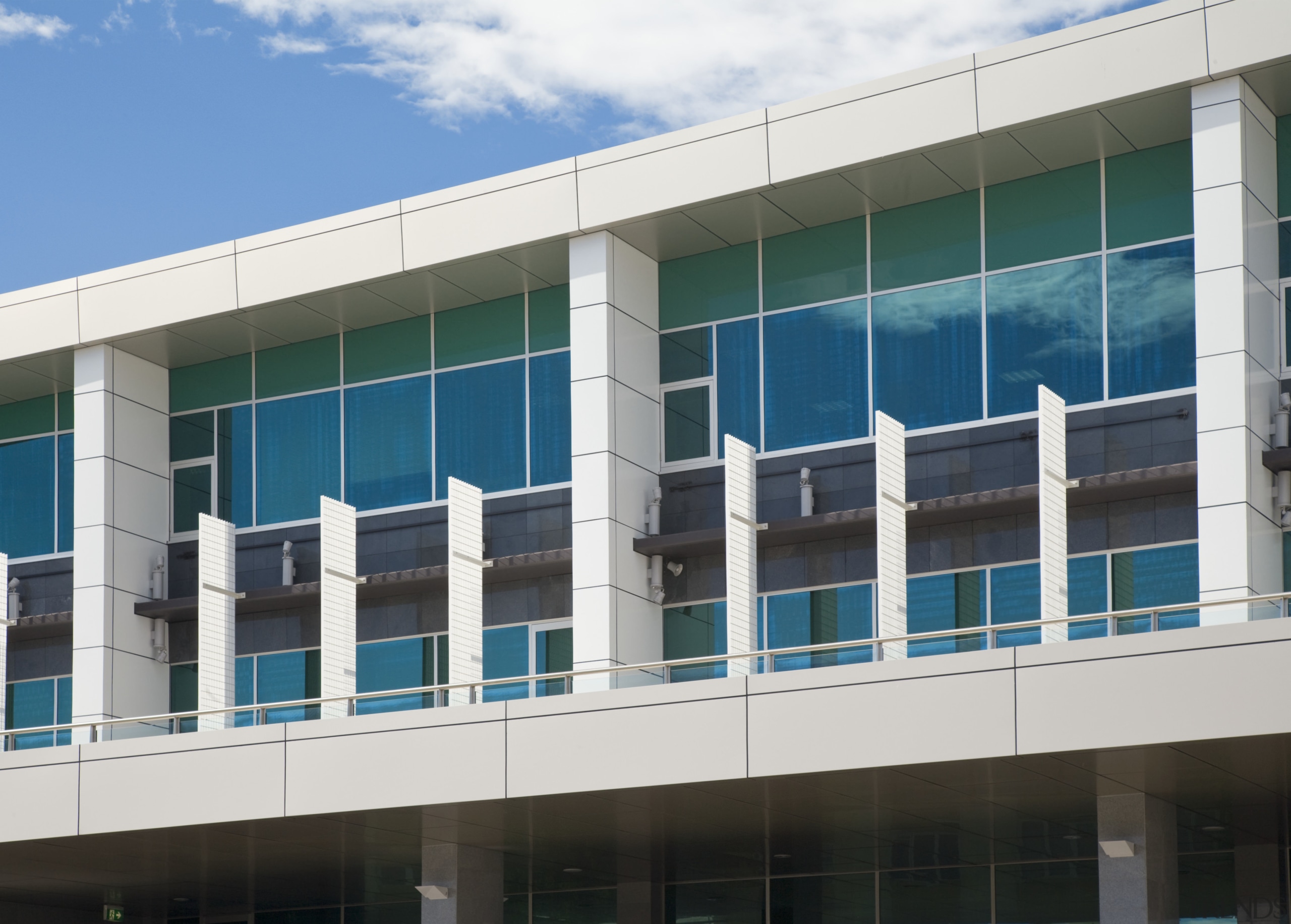 View of an office building featuring glazing which architecture, building, commercial building, corporate headquarters, daytime, facade, headquarters, metropolitan area, mixed use, real estate, sky, window, white, teal