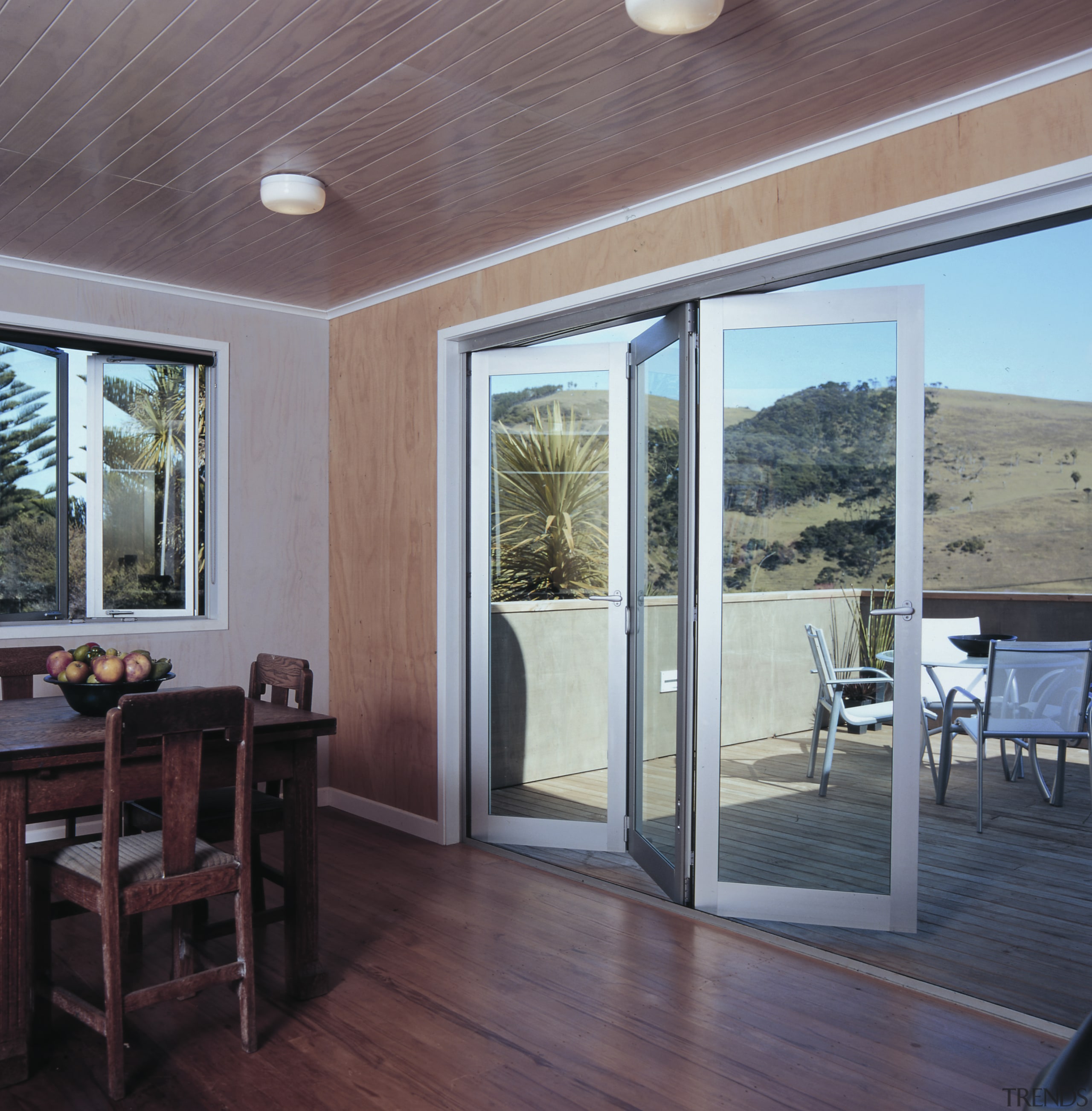 Dining room with wood panel walls, ceiling and deck, door, floor, flooring, house, interior design, patio, porch, real estate, window, gray