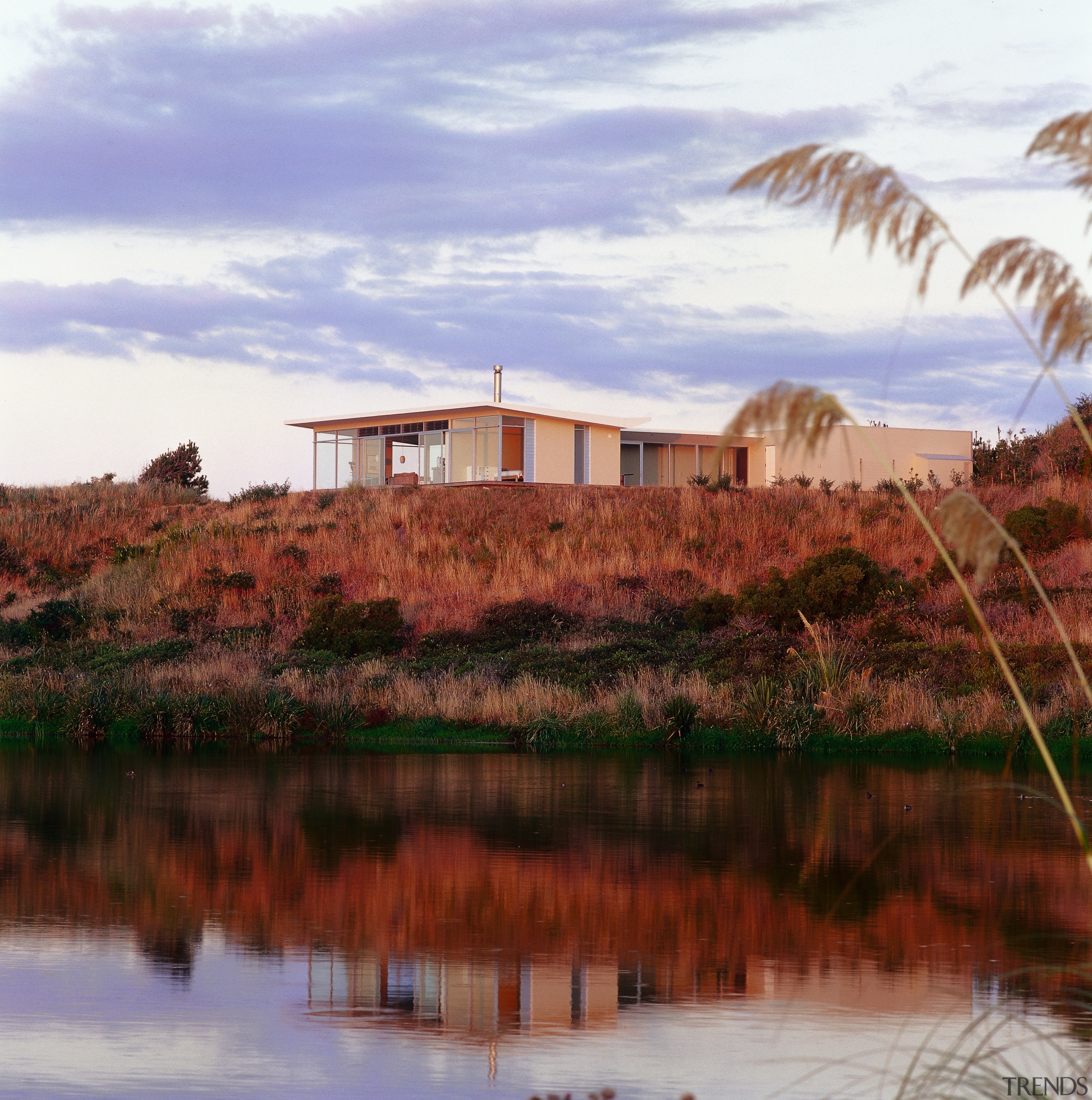 An exterior view of this holiday nestled amongst cloud, house, landscape, loch, real estate, reflection, sky, water, teal