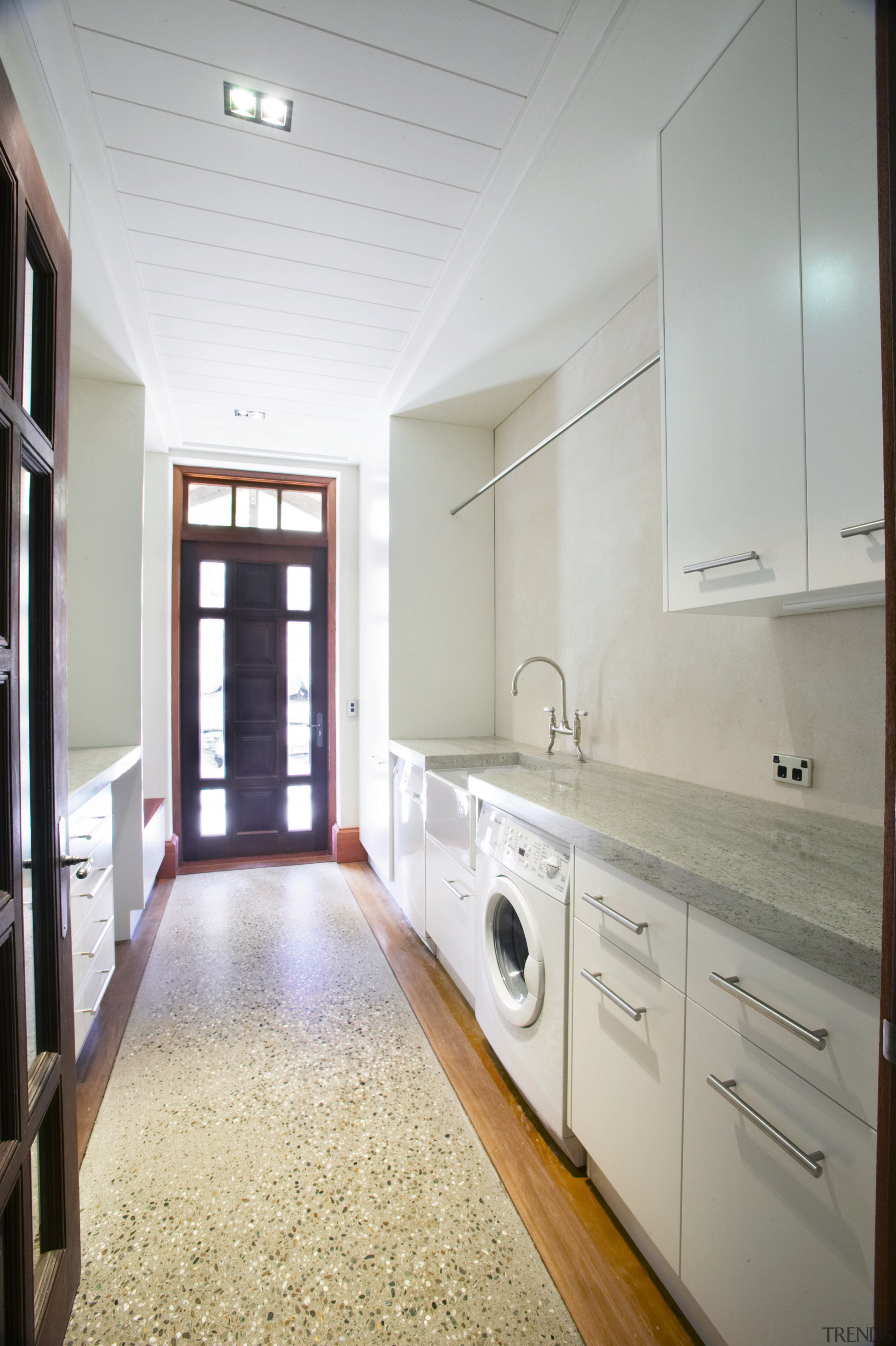 The view of a laundry of a home cabinetry, countertop, floor, home, interior design, kitchen, laundry room, real estate, room, gray