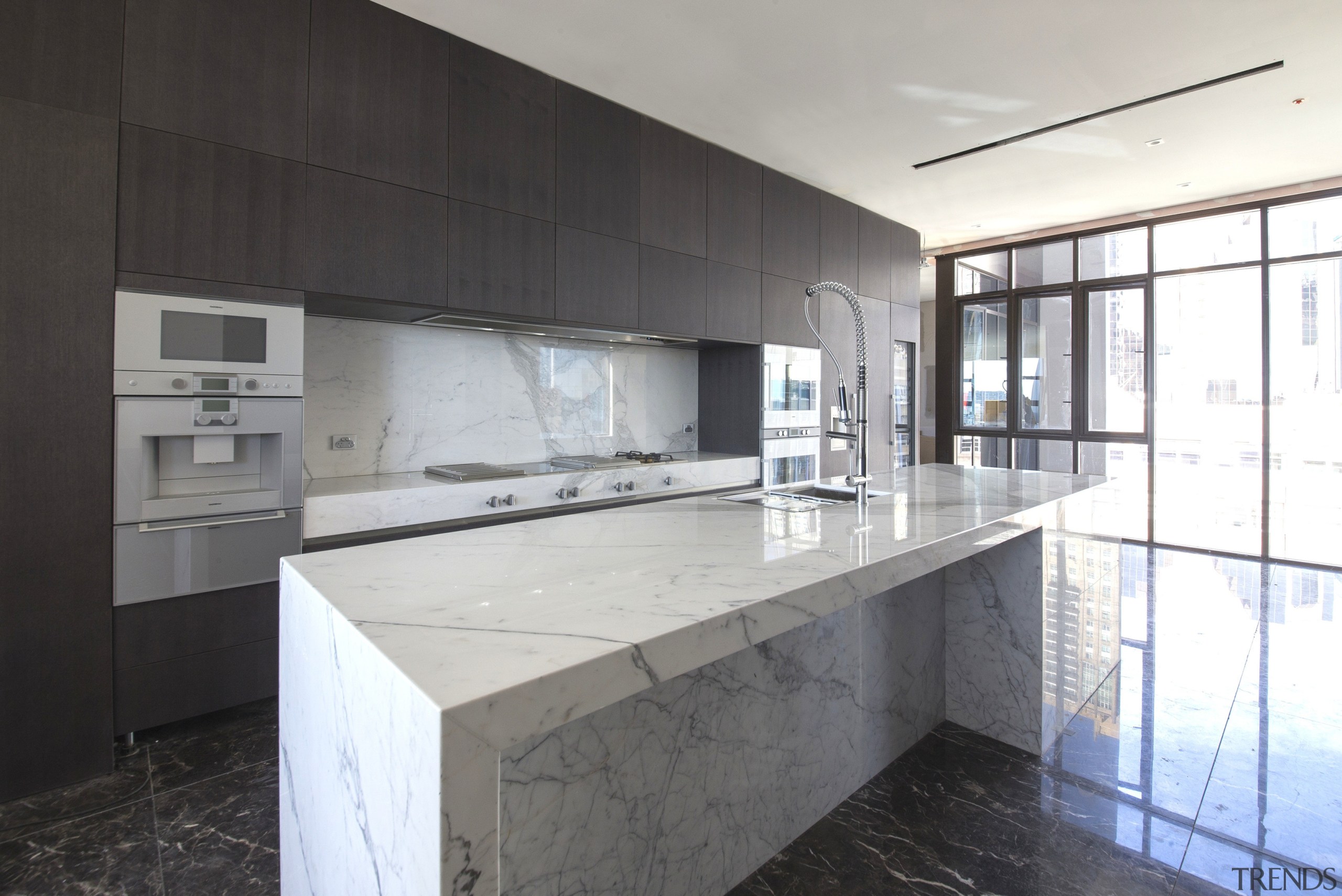 This white marble kitchen island and splashback contrast architecture, countertop, house, interior design, kitchen, property, real estate, white, black