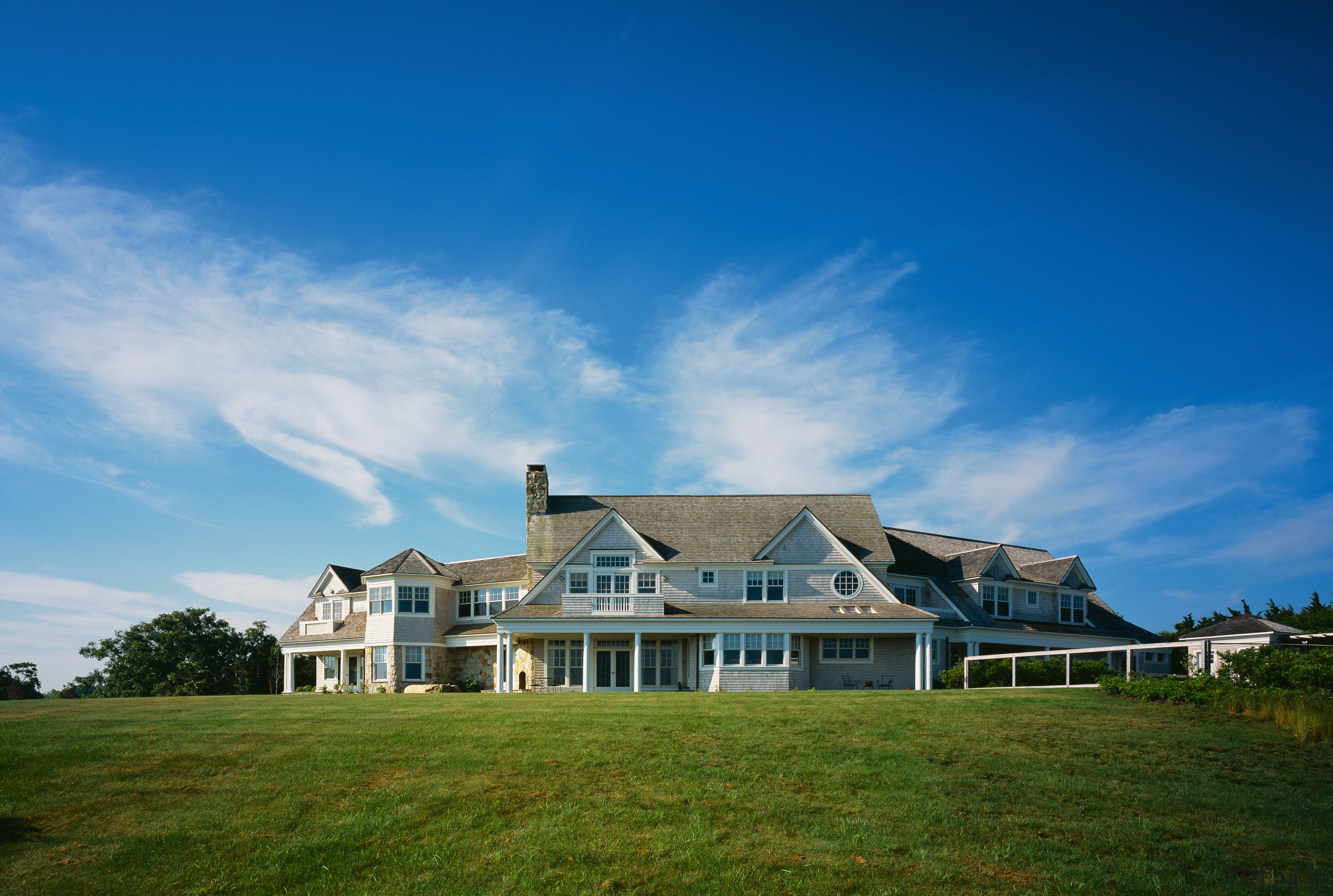 Exterior view of large house with gable roofing cloud, cottage, estate, facade, farm, farmhouse, field, grass, grassland, highland, home, house, land lot, landscape, mansion, meadow, property, real estate, residential area, rural area, sky, suburb, blue