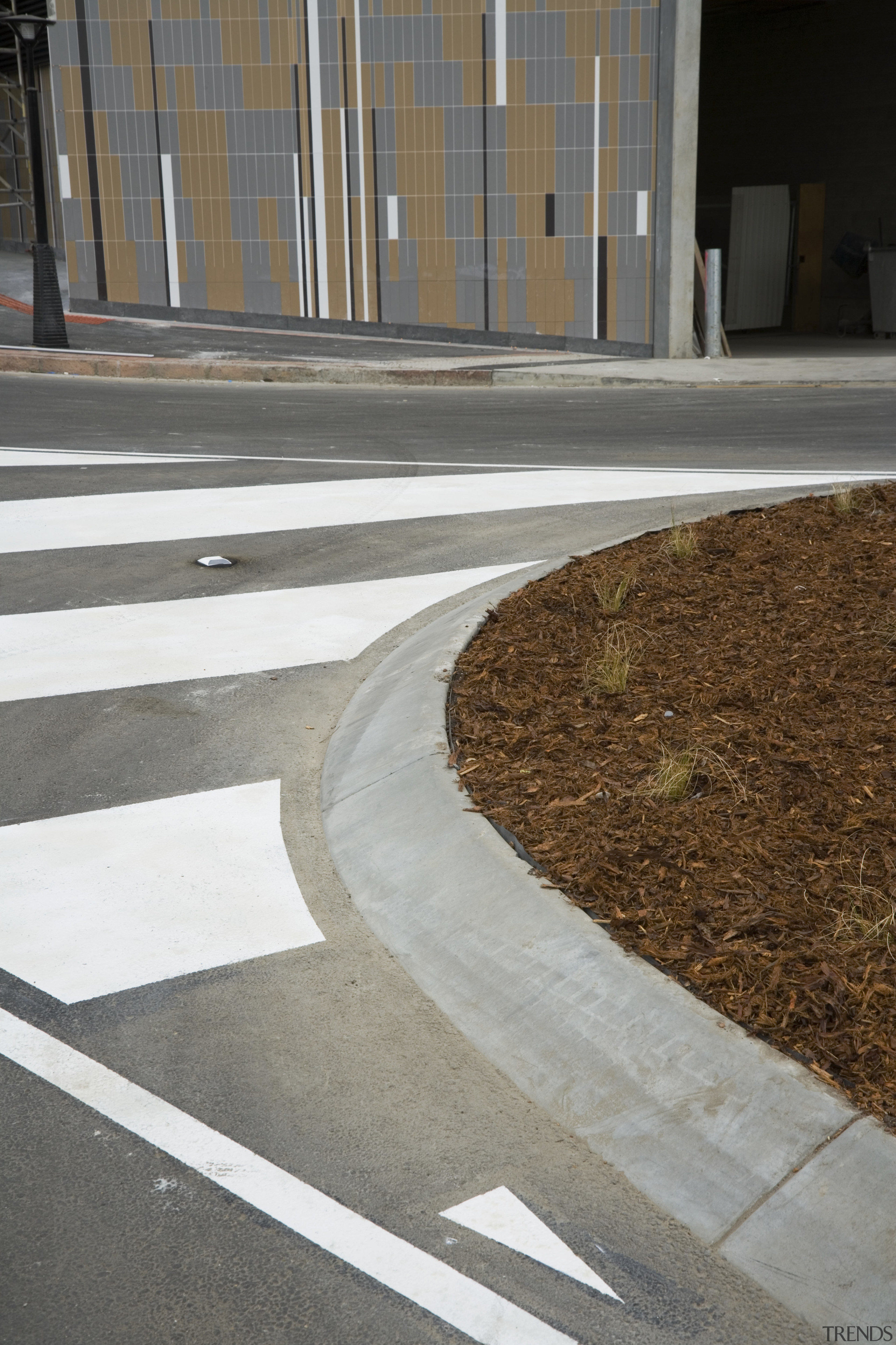 An exterior view of the Greensquare builing and architecture, asphalt, floor, lane, line, road surface, shadow, sidewalk, walkway, gray