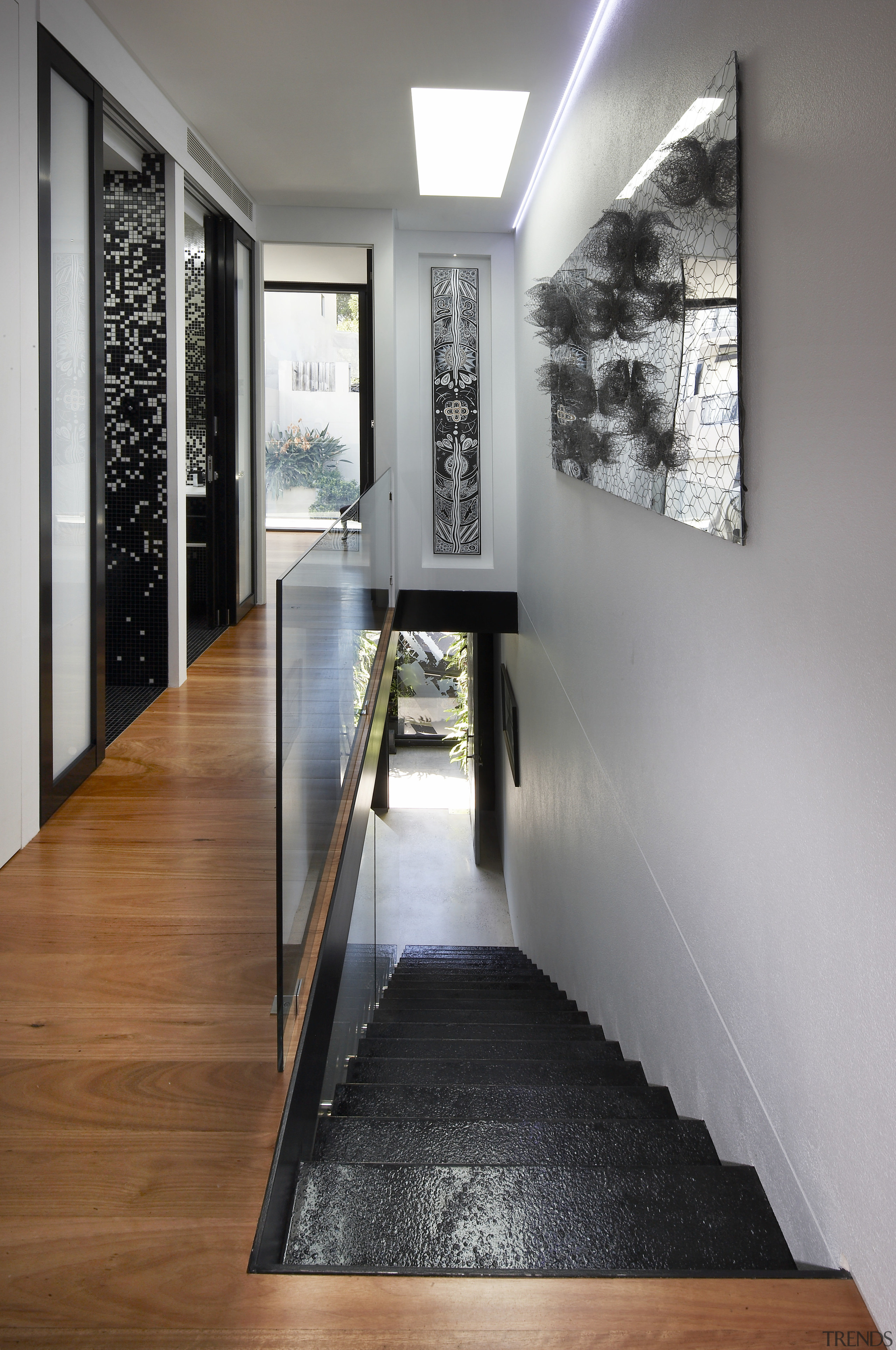 A skylight at the top of the stairs floor, flooring, hardwood, interior design, wood flooring, gray