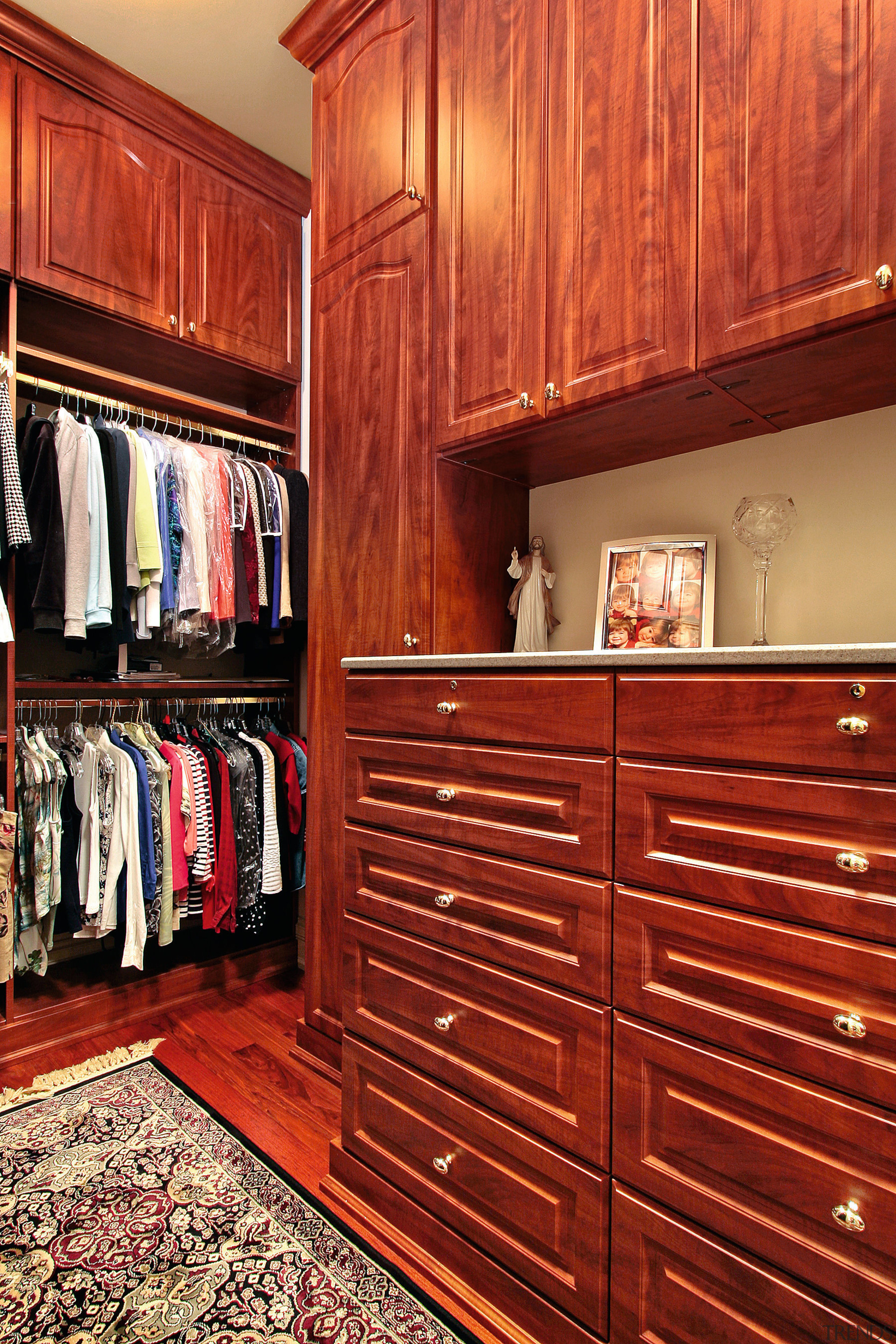 The high ceiling in this Tara Designer Homes cabinetry, chest of drawers, closet, flooring, furniture, hardwood, room, wardrobe, wood, wood stain, red