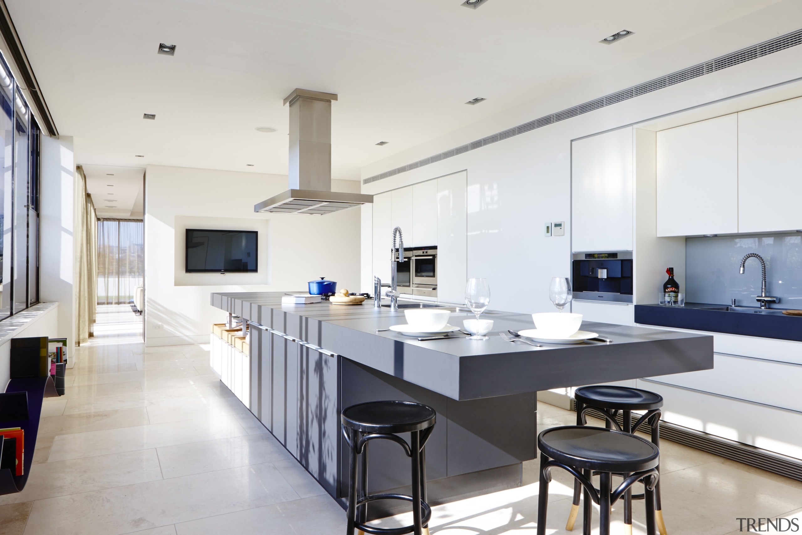 A cantilevered end to this 4.6m-long island forms countertop, interior design, kitchen, room, white