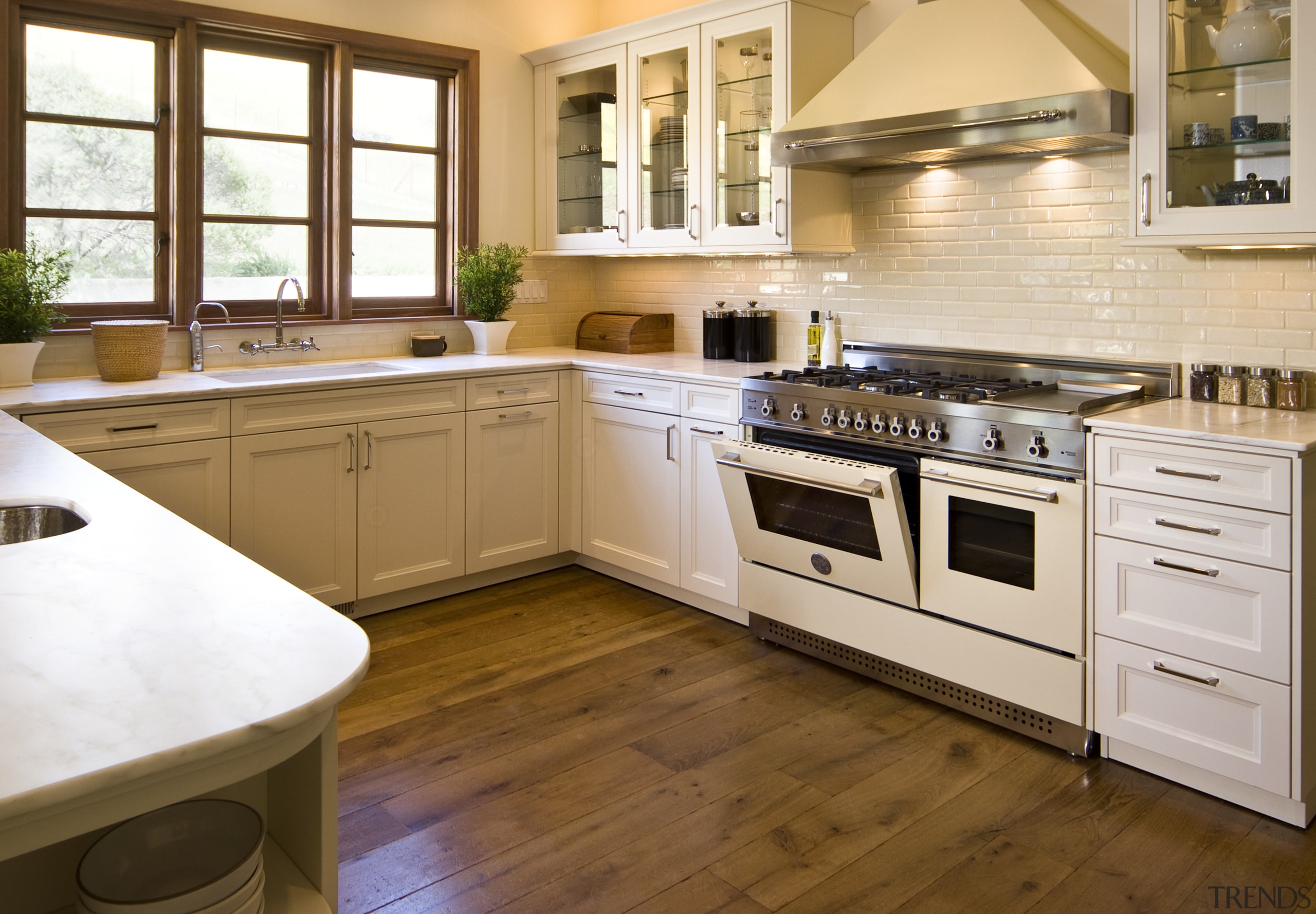 View of a traditional-styled kitchen which features stainless cabinetry, countertop, cuisine classique, floor, flooring, hardwood, interior design, kitchen, laminate flooring, room, wood flooring, brown, white