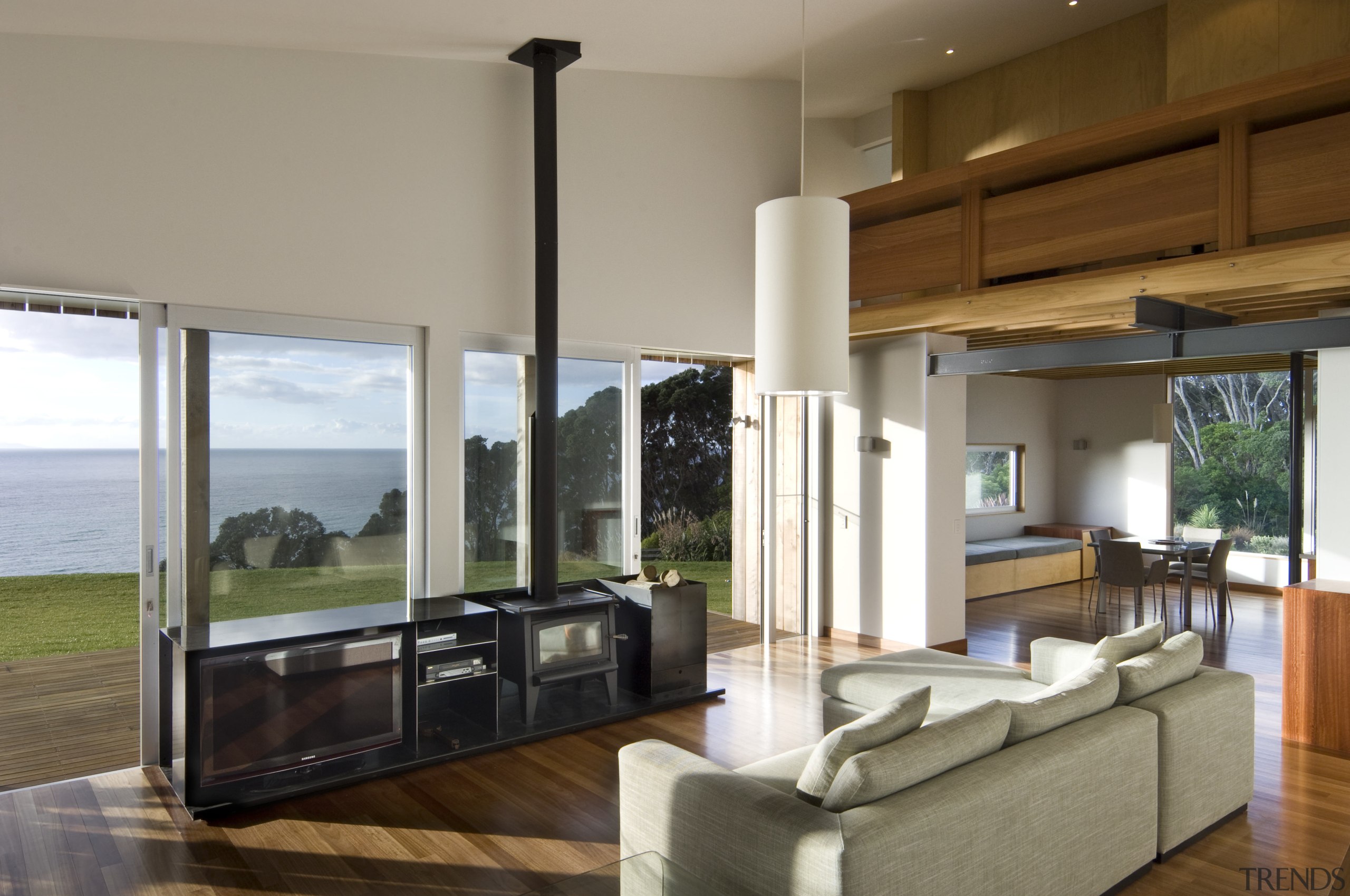 View of living area which features exposed joists, architecture, condominium, floor, hardwood, house, interior design, living room, real estate, window, wood flooring, gray, brown