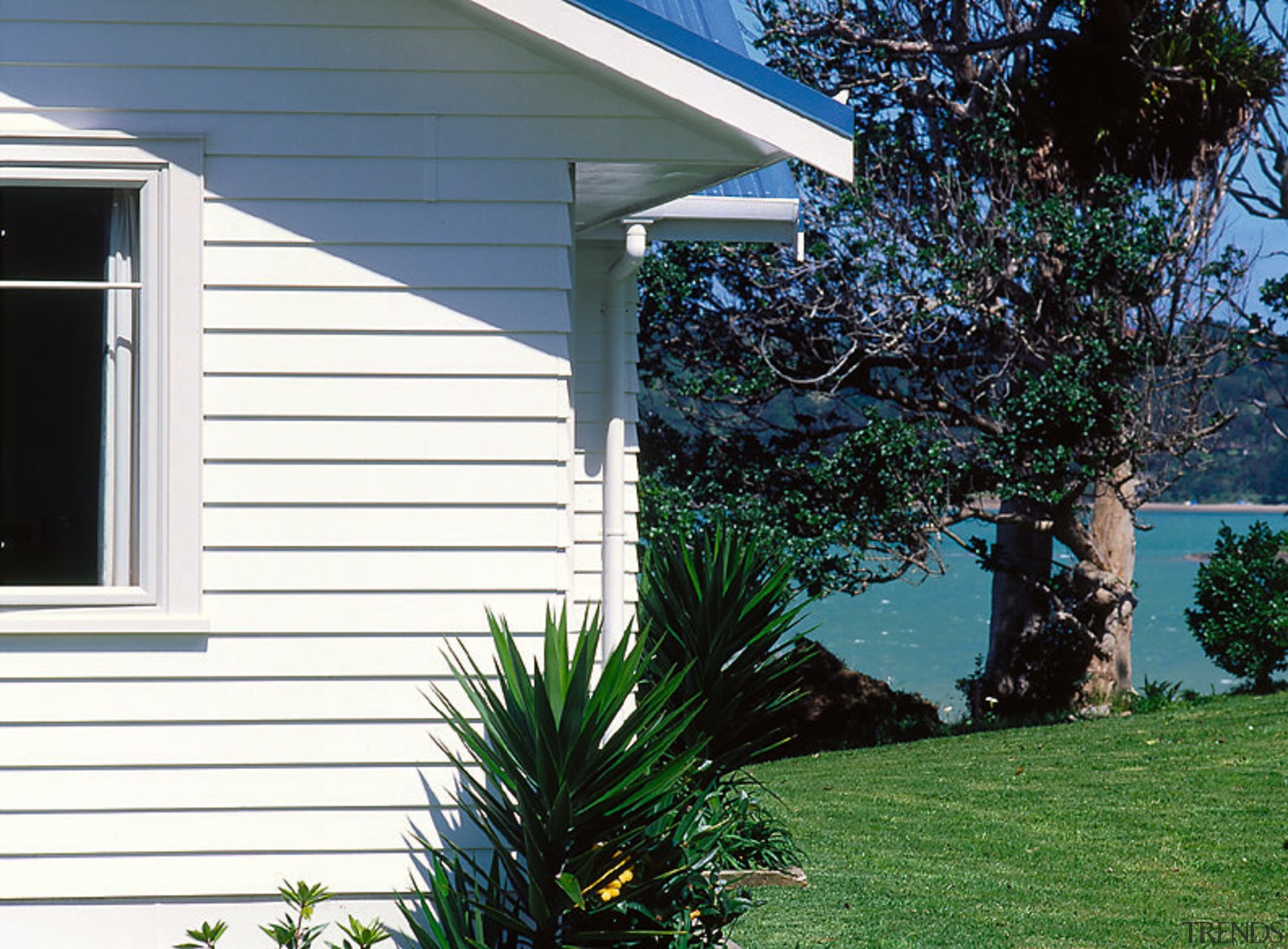 A photograph featuring weatherboards. The photo also includes backyard, cottage, facade, grass, home, house, landscaping, lawn, outdoor structure, plant, property, real estate, siding, tree, window, yard, white