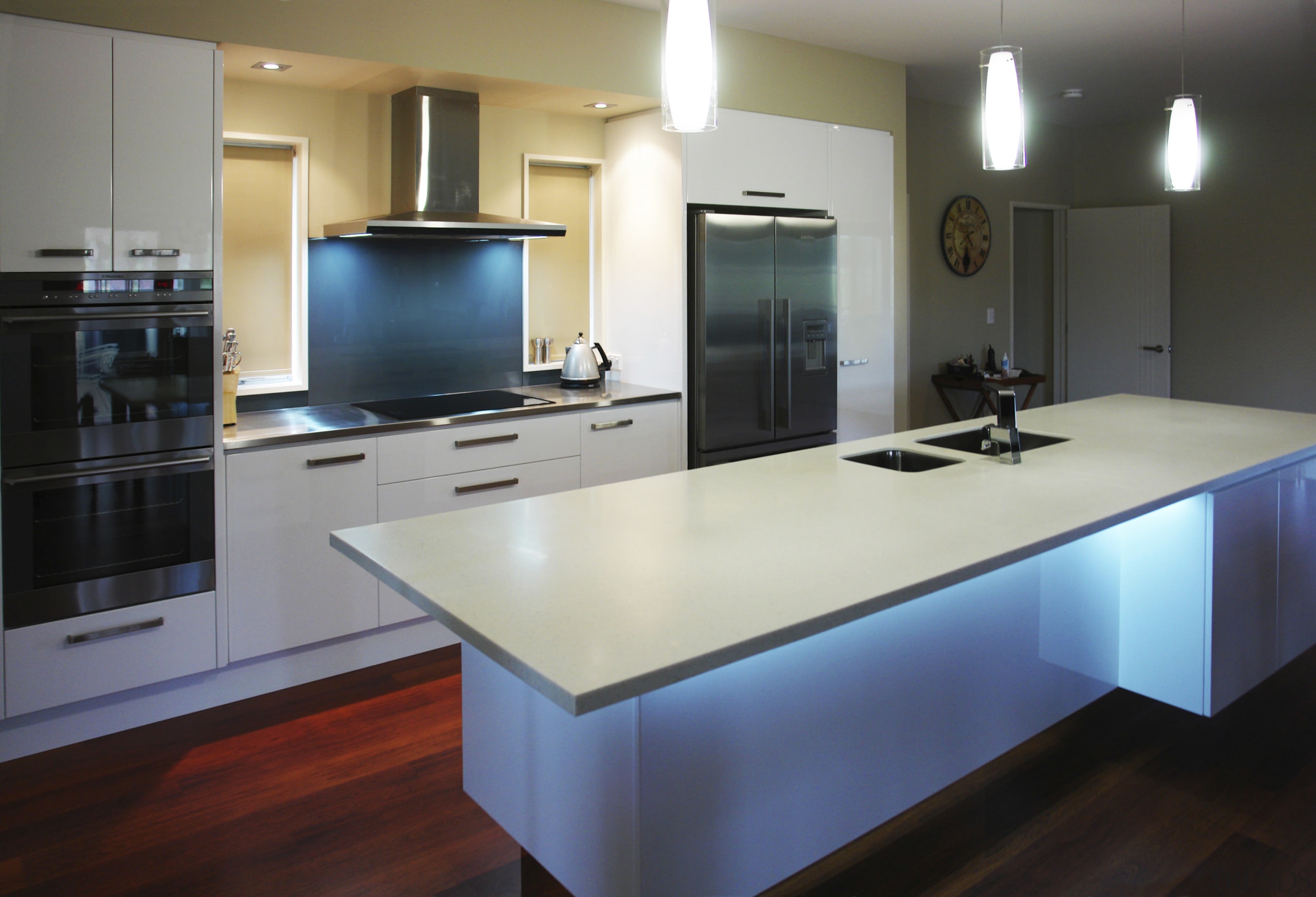 View of a kitchen which features an island cabinetry, countertop, floor, hardwood, interior design, kitchen, real estate, room, gray, black