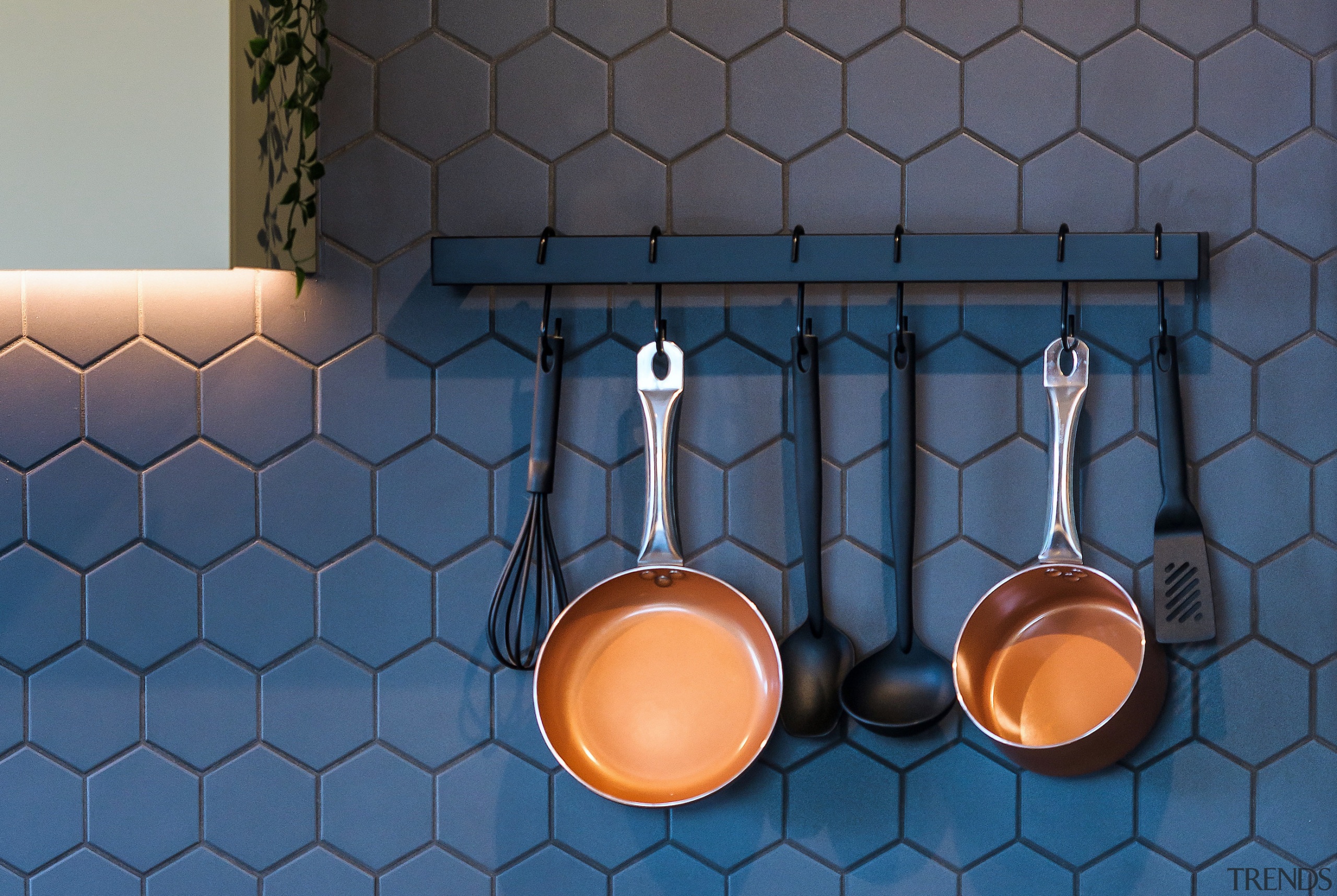 Copper pans stand out against the hexagonal tile 