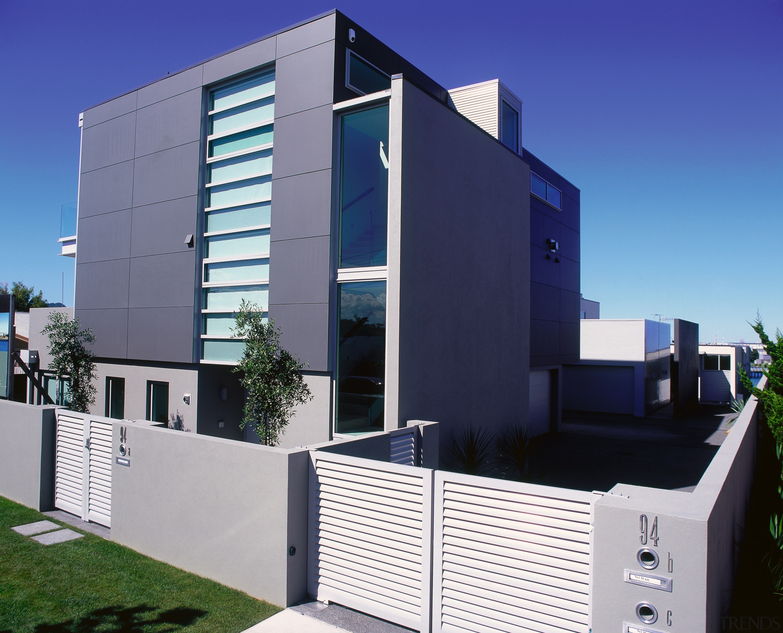 view of this contemporary townhouse featuring alluminium cladding, architecture, building, commercial building, condominium, corporate headquarters, elevation, facade, home, house, property, real estate, residential area, blue