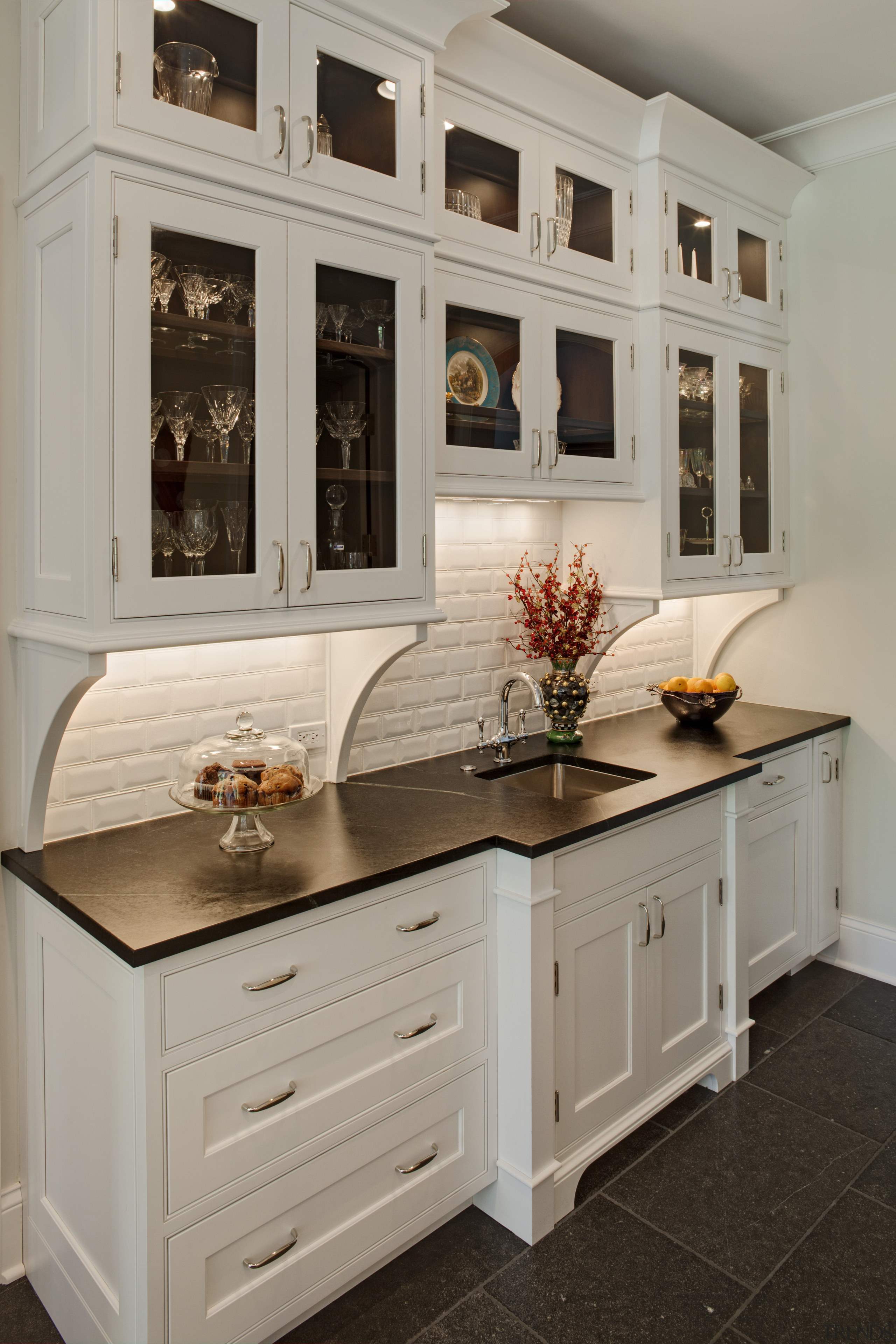 Arched openings. Red splash back. Limestone floors. White cabinetry, chest of drawers, countertop, cuisine classique, drawer, furniture, interior design, kitchen, room, wood stain, gray