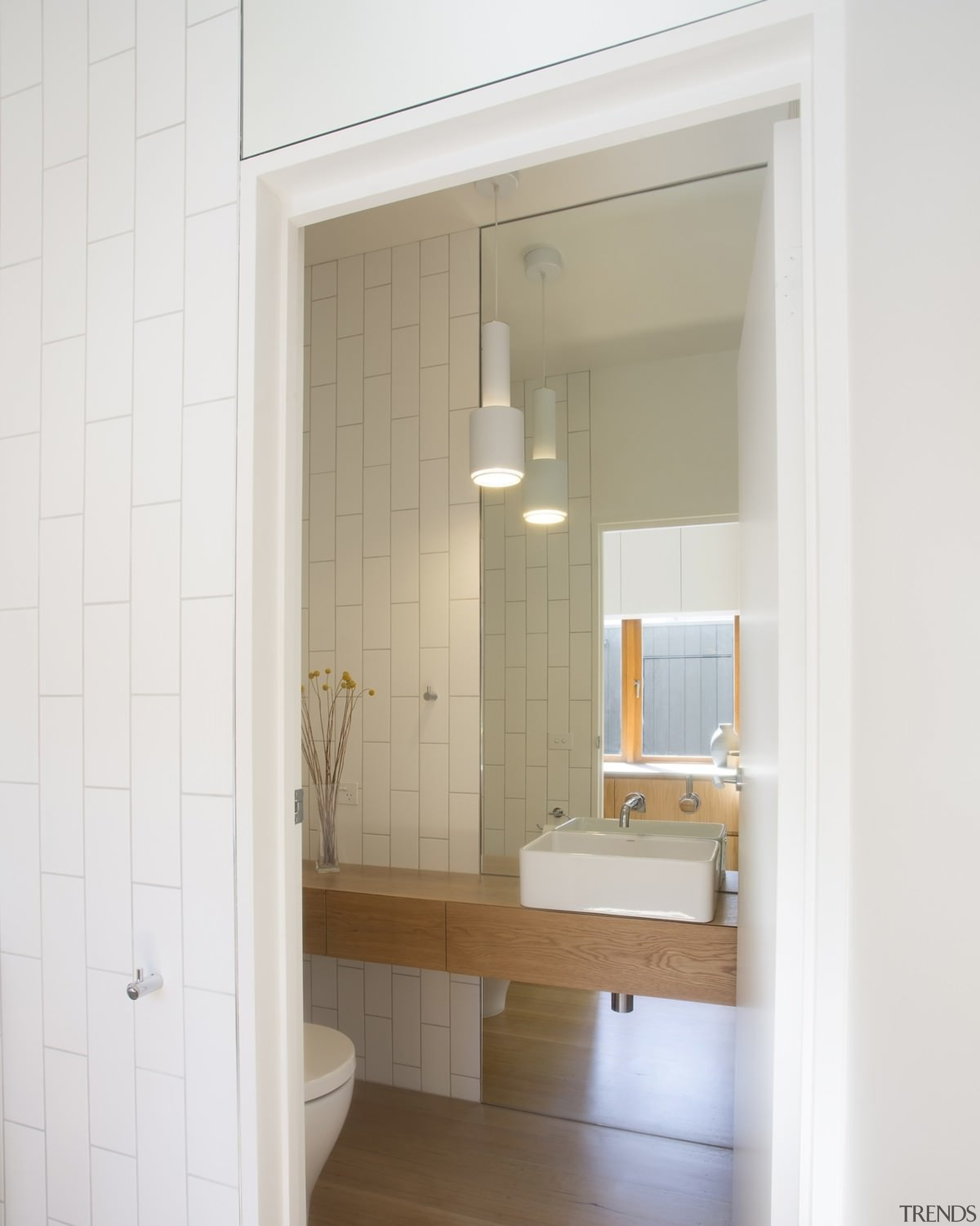 This powder room tucked off to the side, bathroom, bathroom accessory, bathroom cabinet, door, floor, home, interior design, plumbing fixture, room, sink, window, white