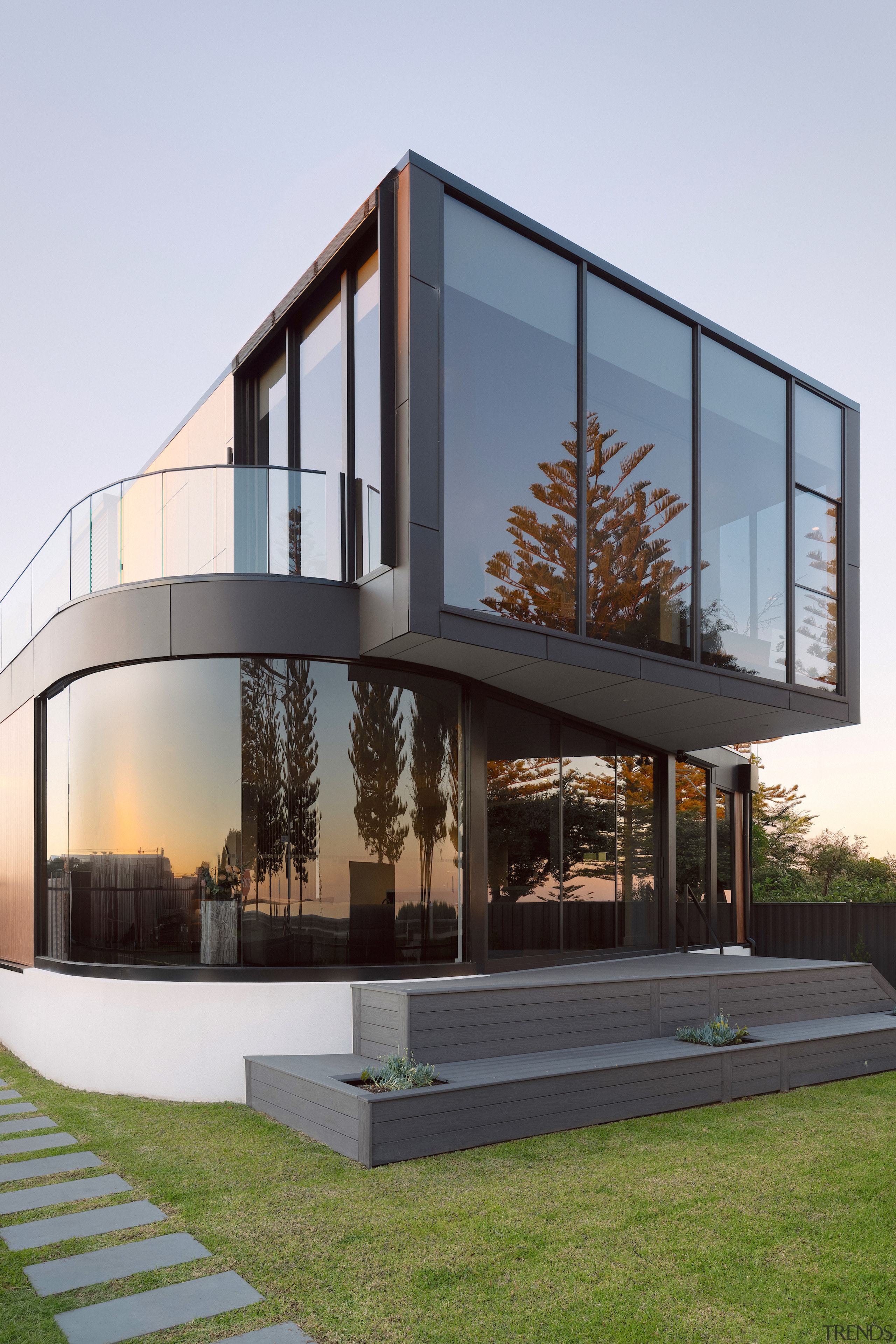 Curved glass windows soften the facade and frame 