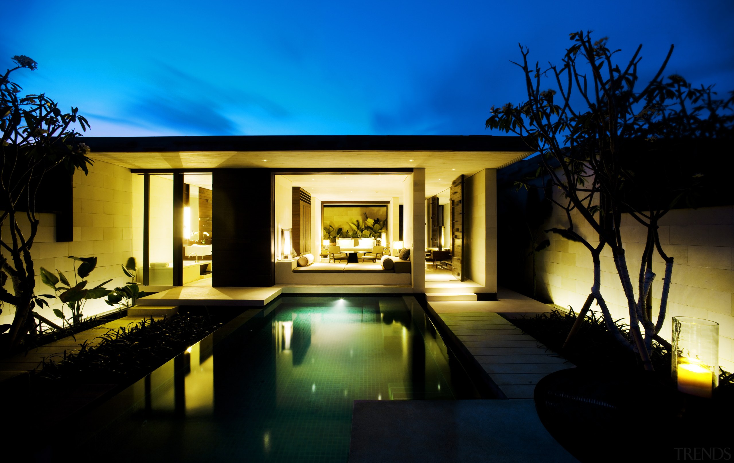 This Balinese villa is clad in limestone, sandstone architecture, estate, evening, home, house, landscape lighting, lighting, property, real estate, reflection, sky, villa, window, black