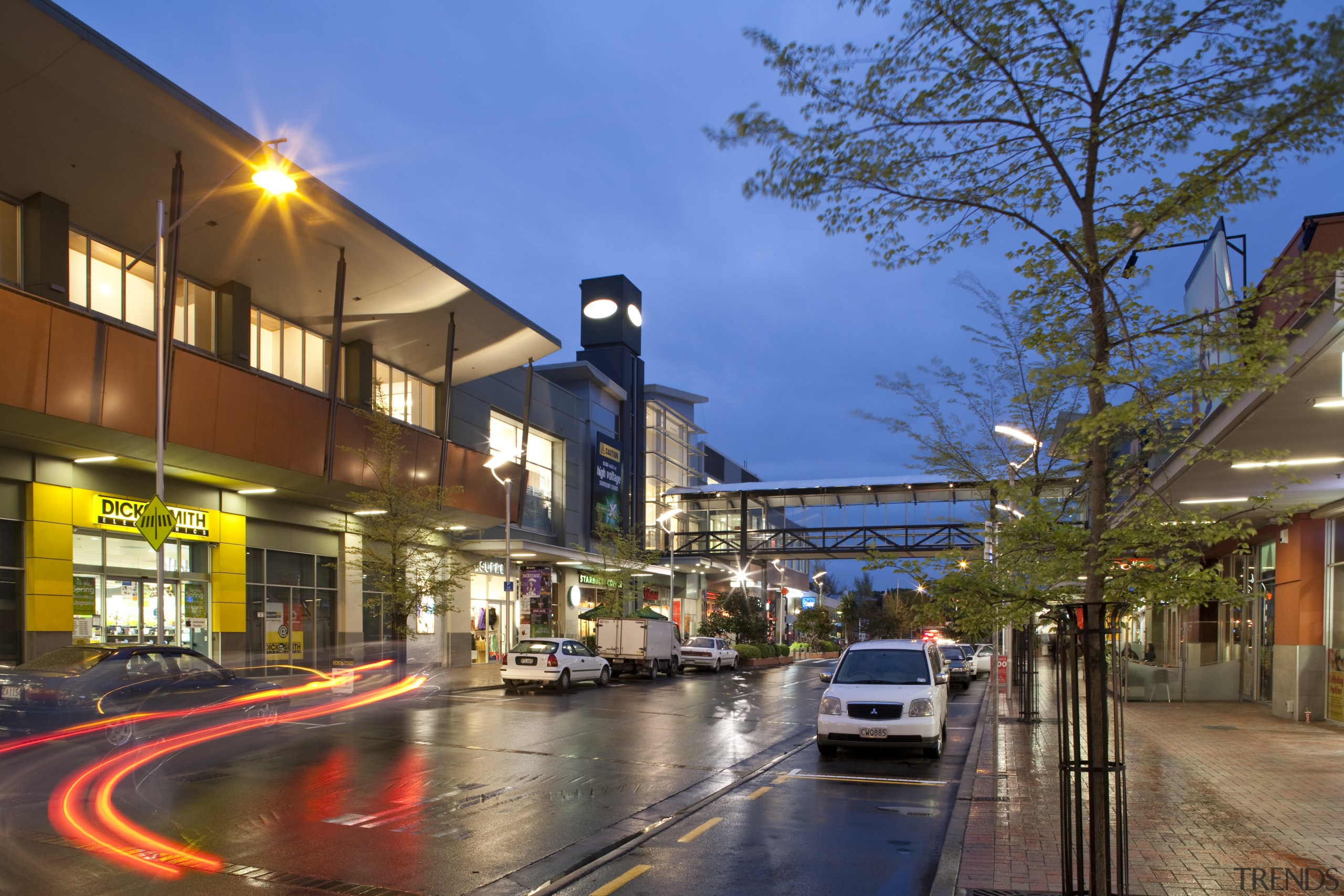 Westfield Riccarton has undergone an extension adding a car, city, downtown, evening, house, lane, metropolitan area, mixed use, neighbourhood, plant, real estate, reflection, residential area, road, sky, street, town, tree, urban area, brown, blue