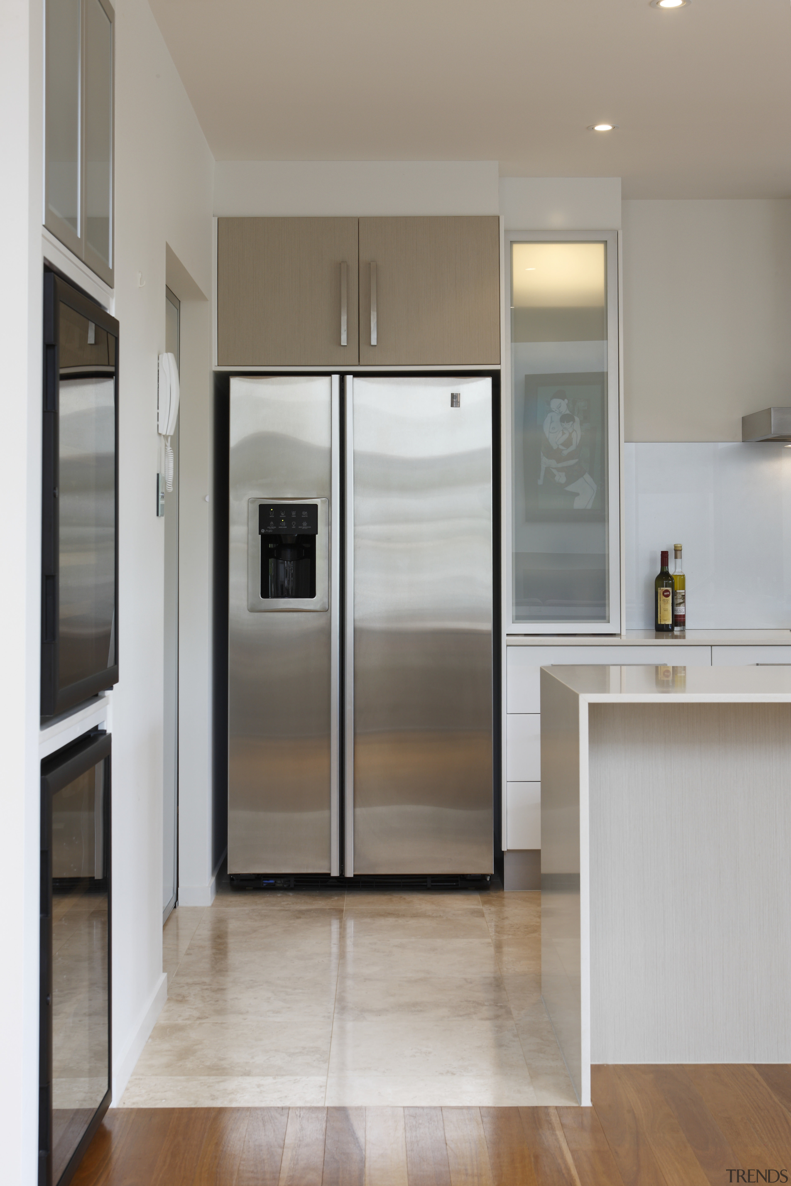 This kitchen combines a strong, simple aesthetic with cabinetry, door, floor, home appliance, interior design, kitchen, refrigerator, gray