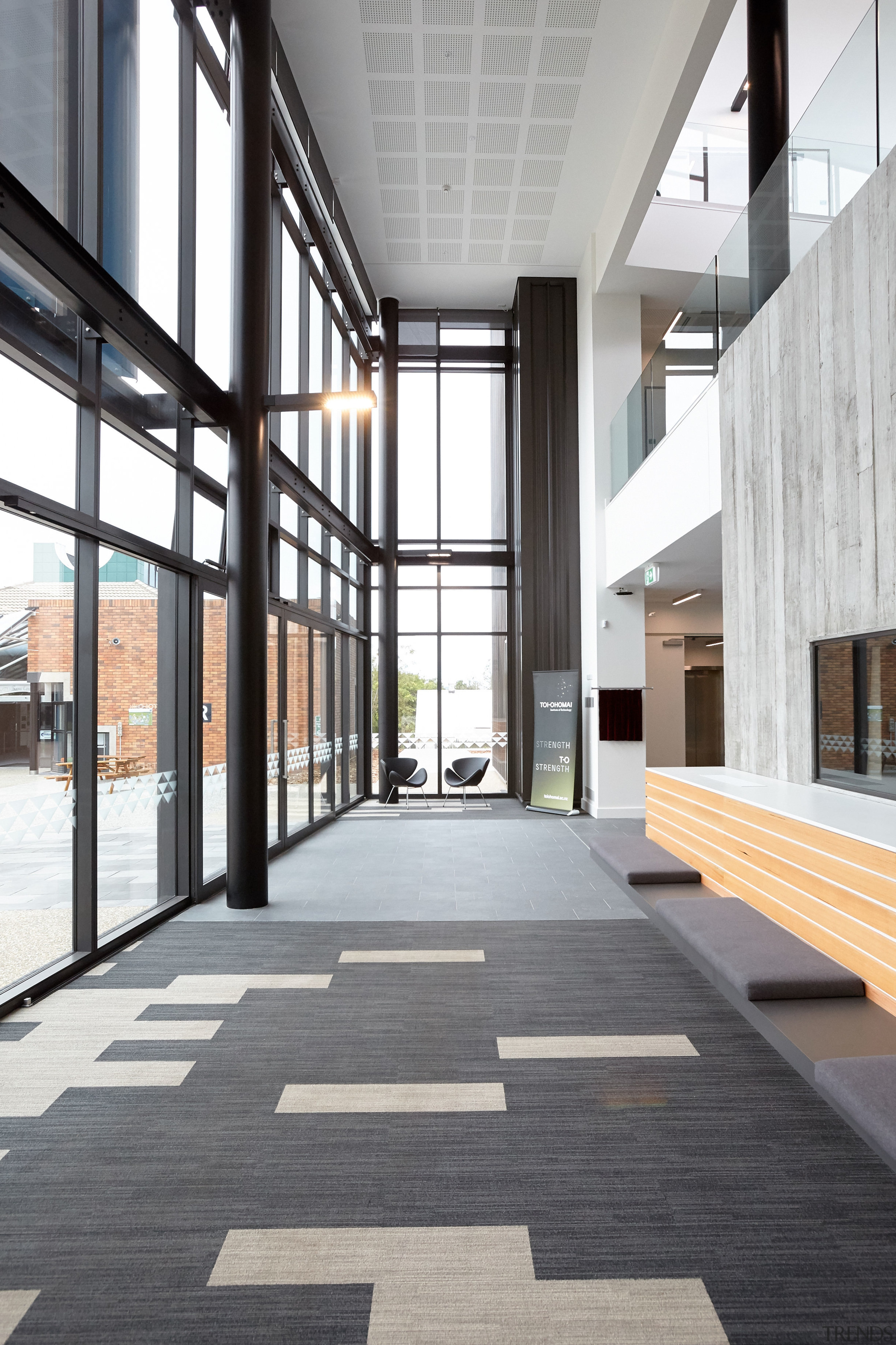 The double-height entry plaza shows how external cladding architecture, building, daylighting, floor, flooring, interior design, lobby, structure, window, wood flooring, white, gray