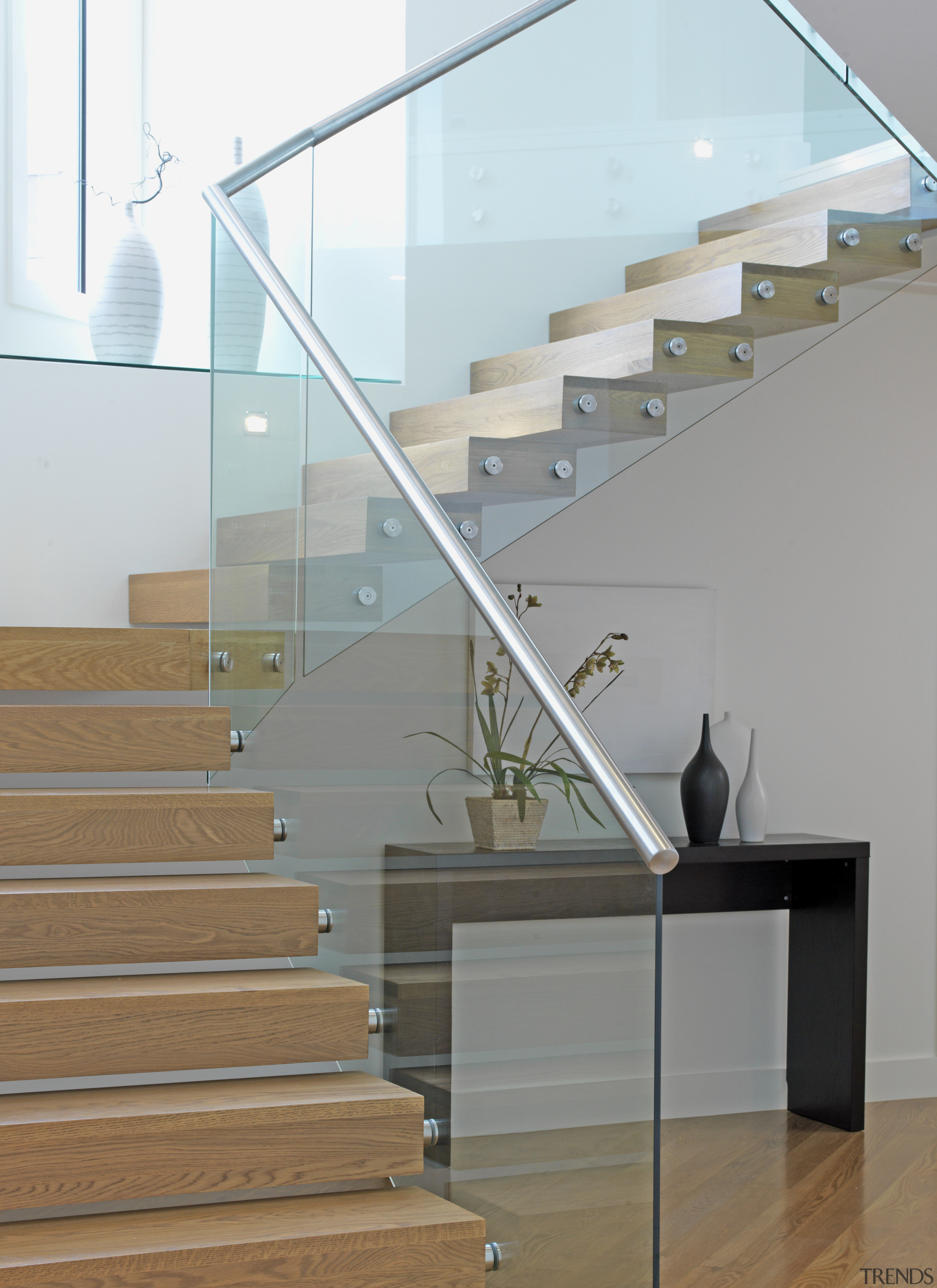 The cantilevered staircase appears to float in the architecture, baluster, daylighting, glass, handrail, interior design, product design, stairs, gray, white