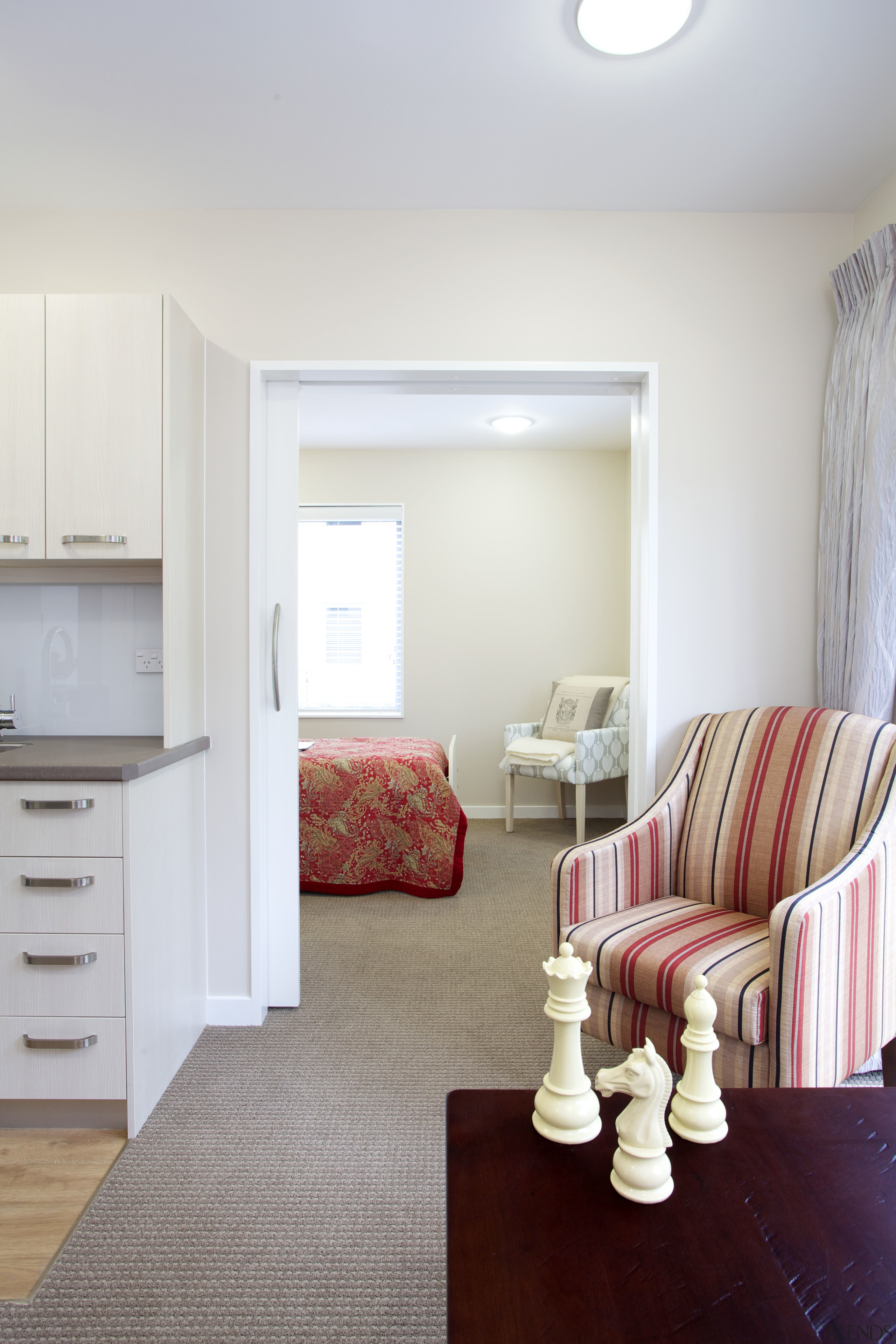 In the Care Suites at Eden Village all ceiling, chair, floor, flooring, furniture, hardwood, home, interior design, living room, room, table, wall, wood, white, gray