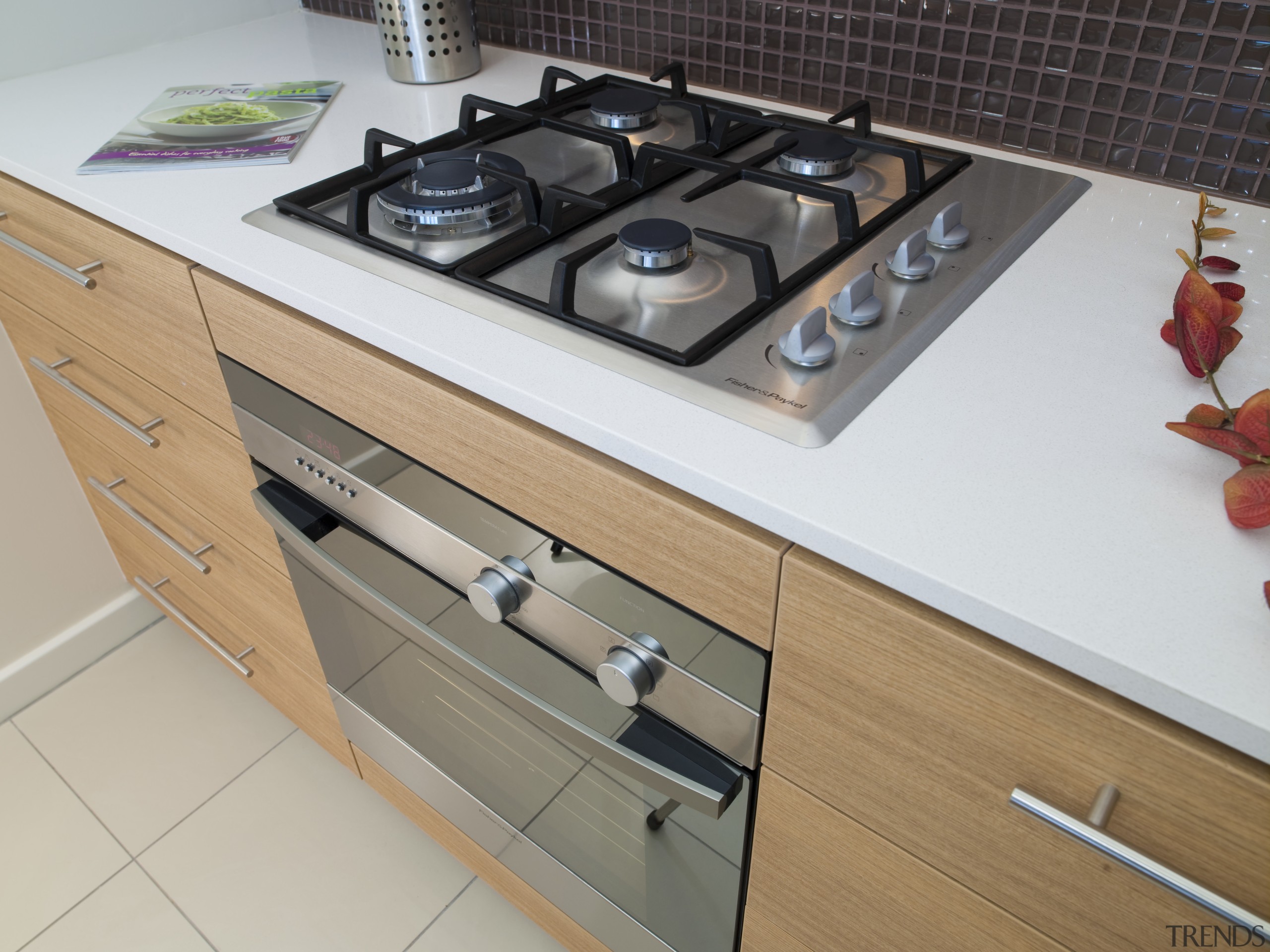 view of apartment kitchen which features Fisher and cabinetry, countertop, drawer, furniture, gas stove, home appliance, kitchen, kitchen appliance, kitchen stove, major appliance, gray