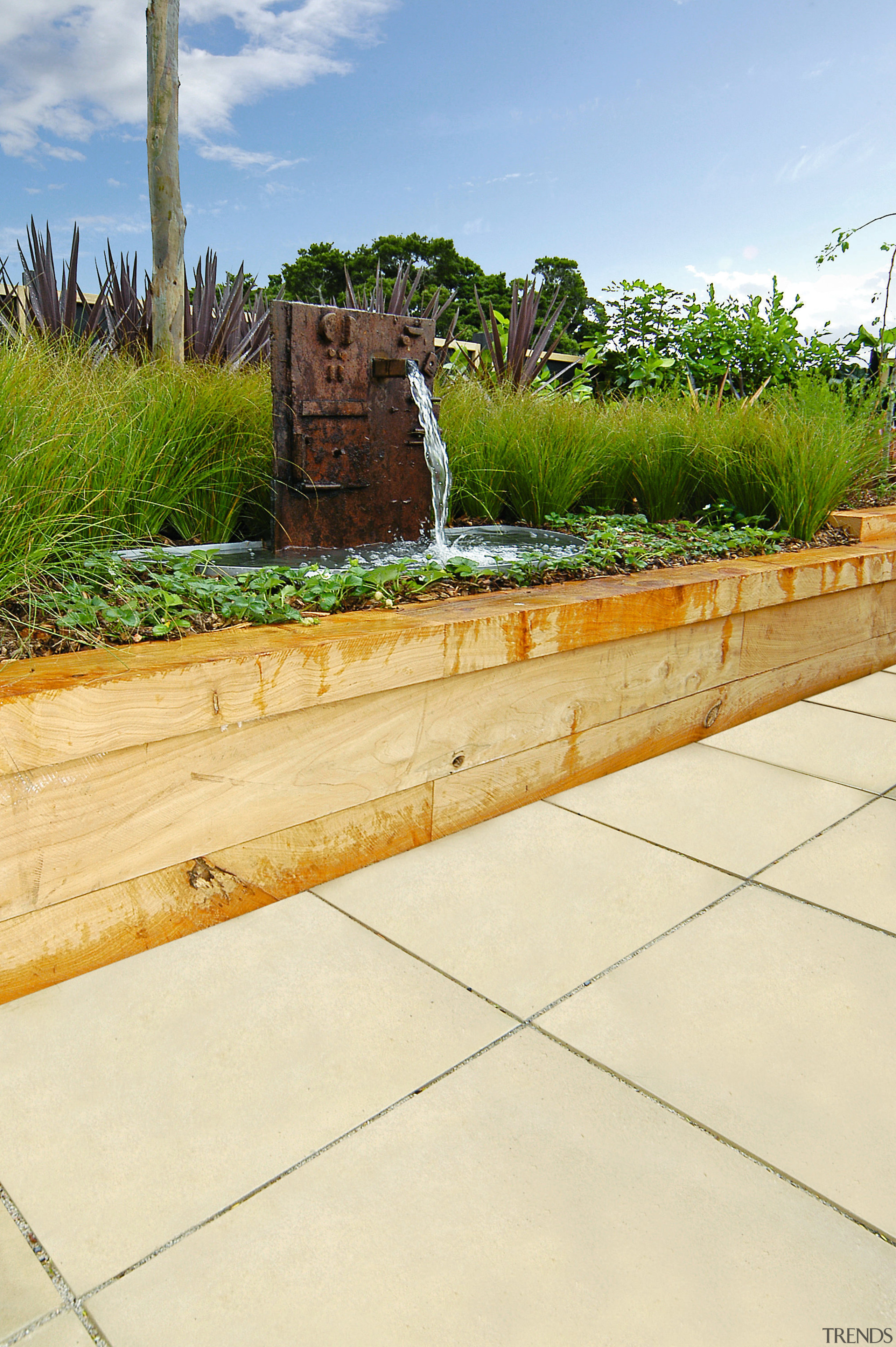 A view of some paving. - A view backyard, grass, landscape, landscaping, outdoor structure, plant, walkway, wall, yard, yellow