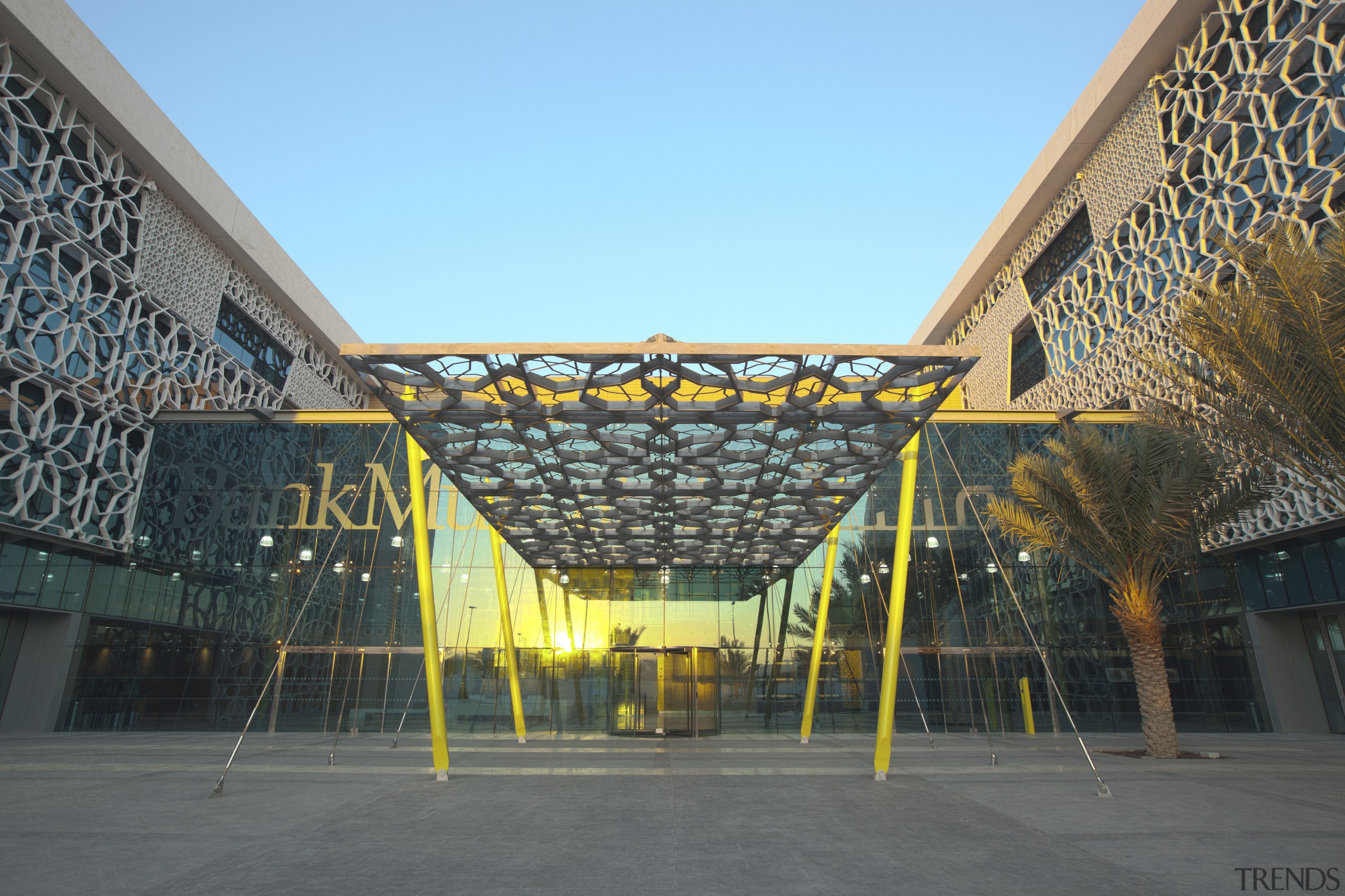 View of exterior with yellow beams at entrance. architecture, building, corporate headquarters, facade, headquarters, landmark, metropolitan area, roof, sky, structure, tourist attraction, urban area, gray, black