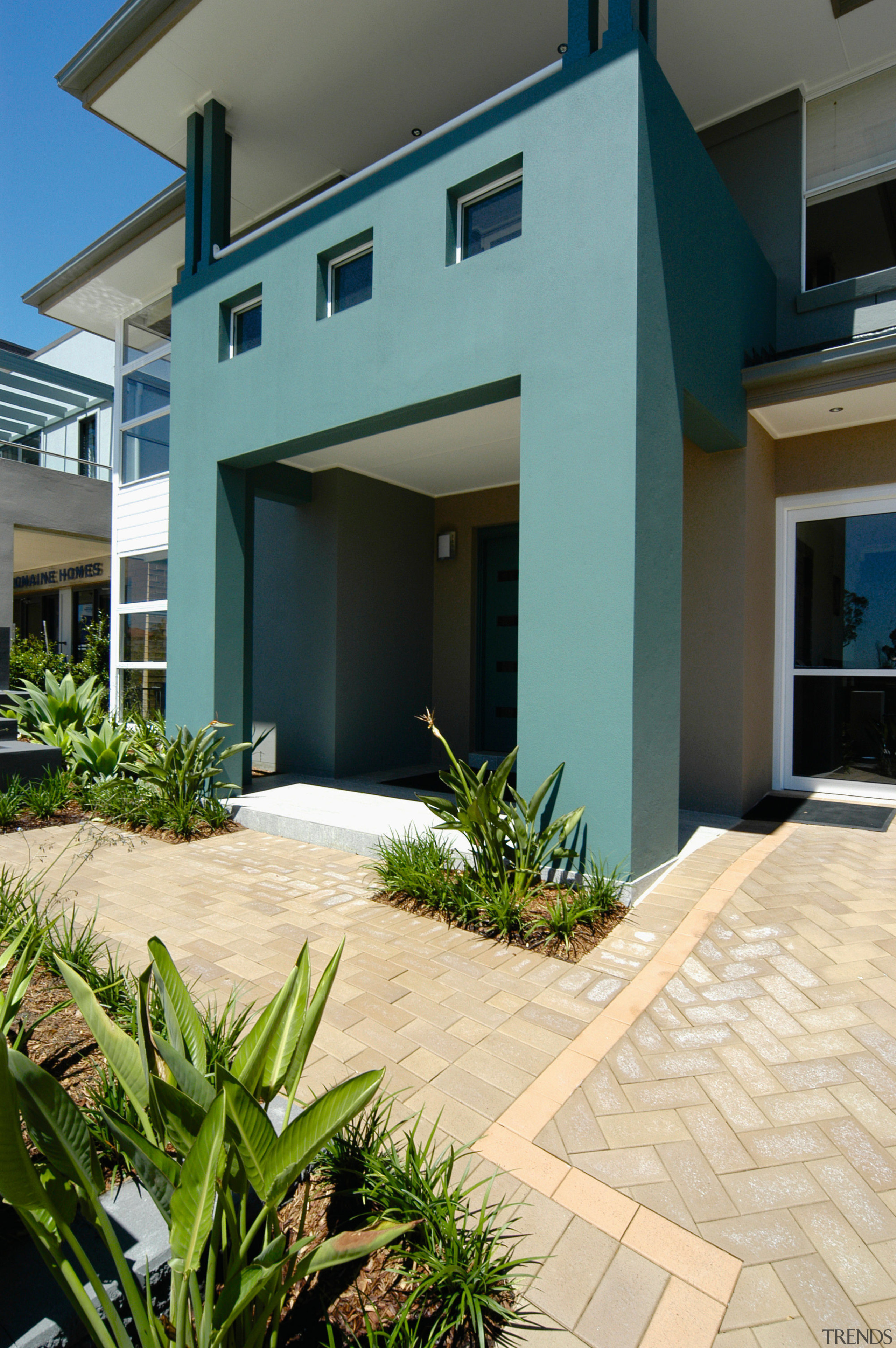 Exterior view of green entrance portico, paving and architecture, building, condominium, estate, facade, home, house, property, real estate, residential area, villa, window