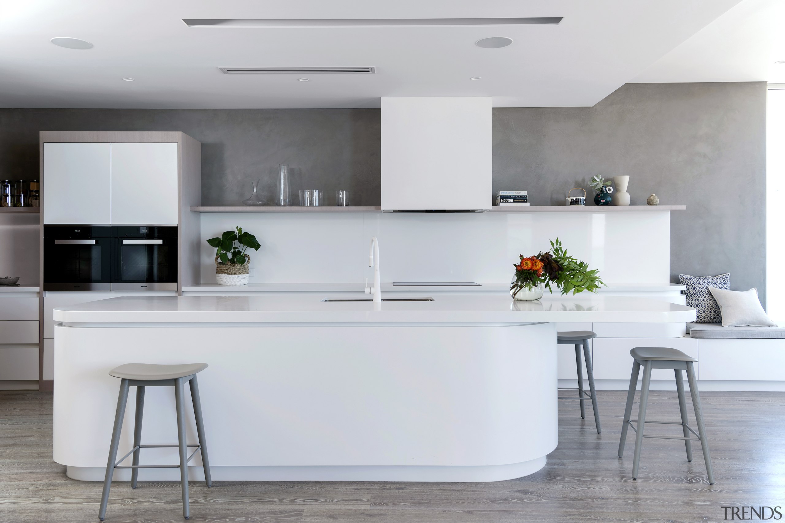 A curvaceous island has a seating area at 