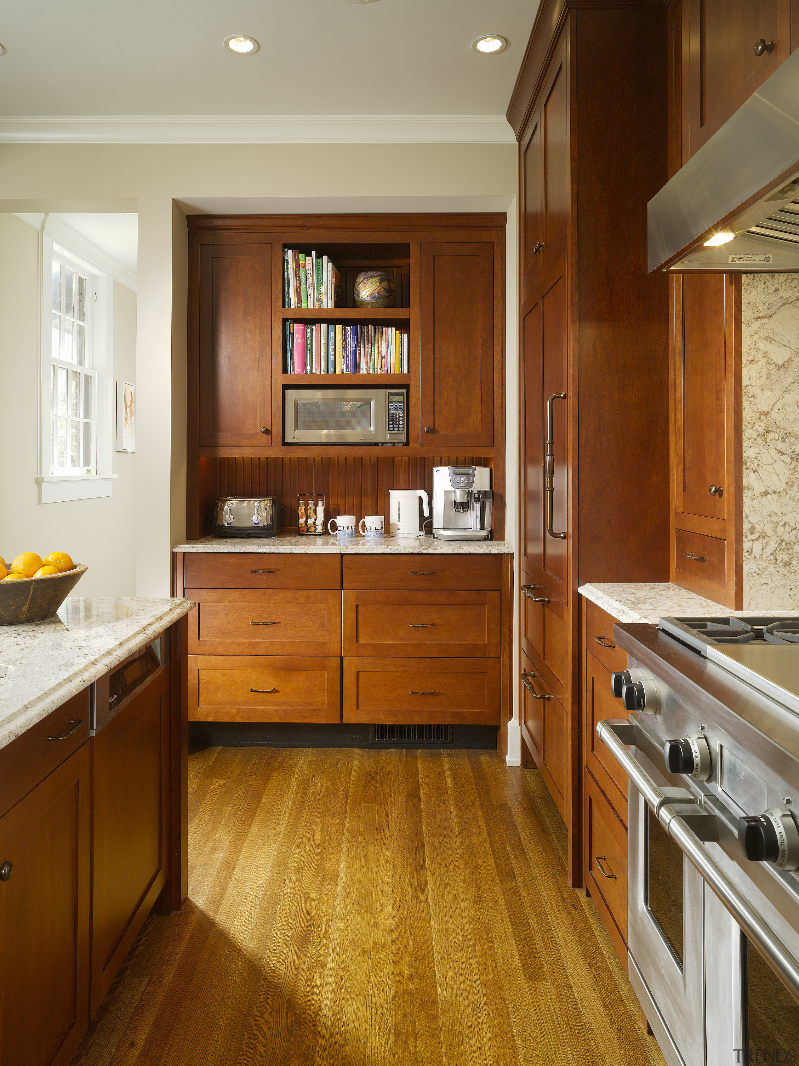 View of kitchen area which features a large cabinetry, countertop, cuisine classique, floor, flooring, hardwood, interior design, kitchen, room, wood, wood flooring, wood stain, brown
