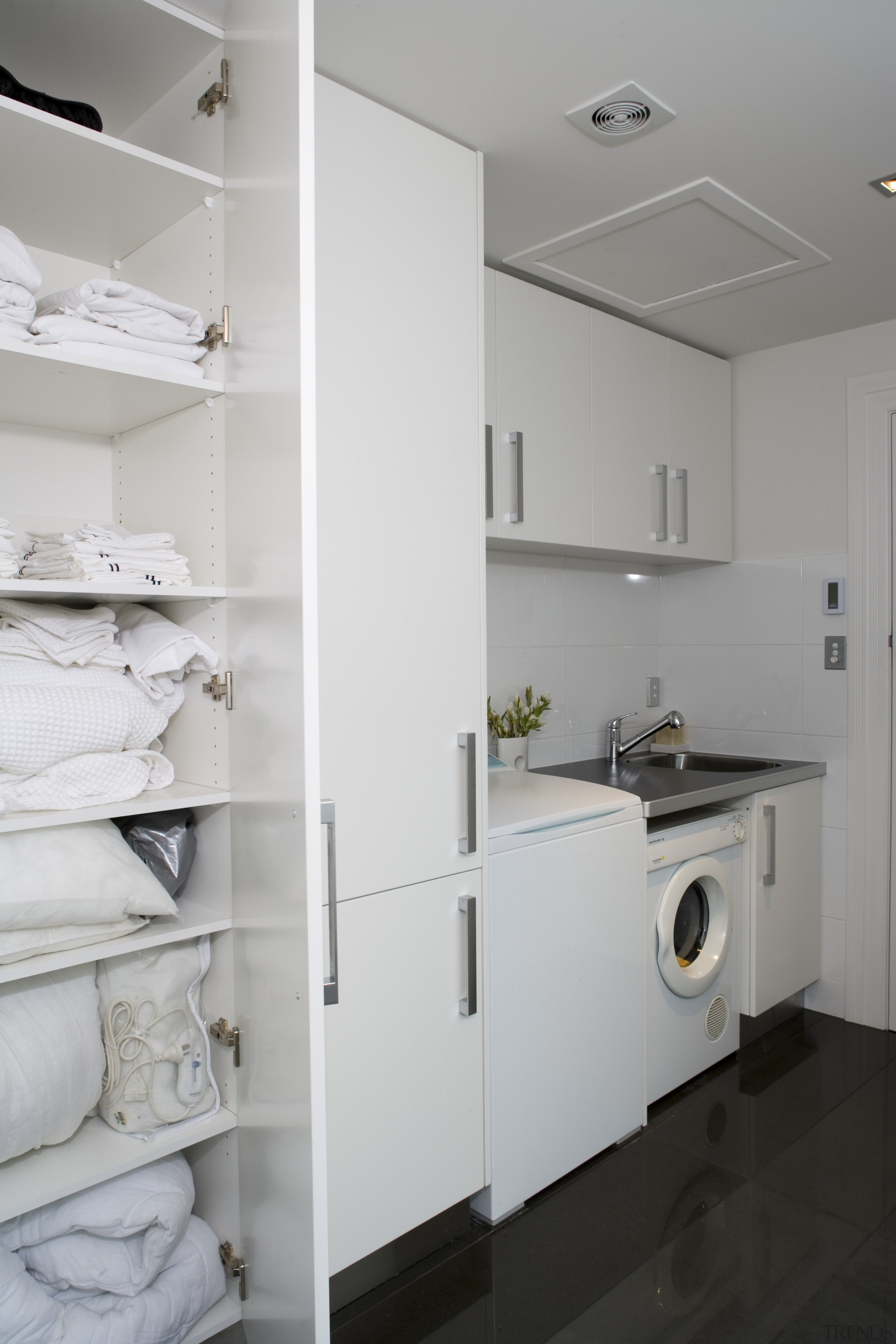 Tall cabinetry provides plenty of storage space. The floor, home, home appliance, interior design, kitchen, laundry, laundry room, major appliance, room, gray