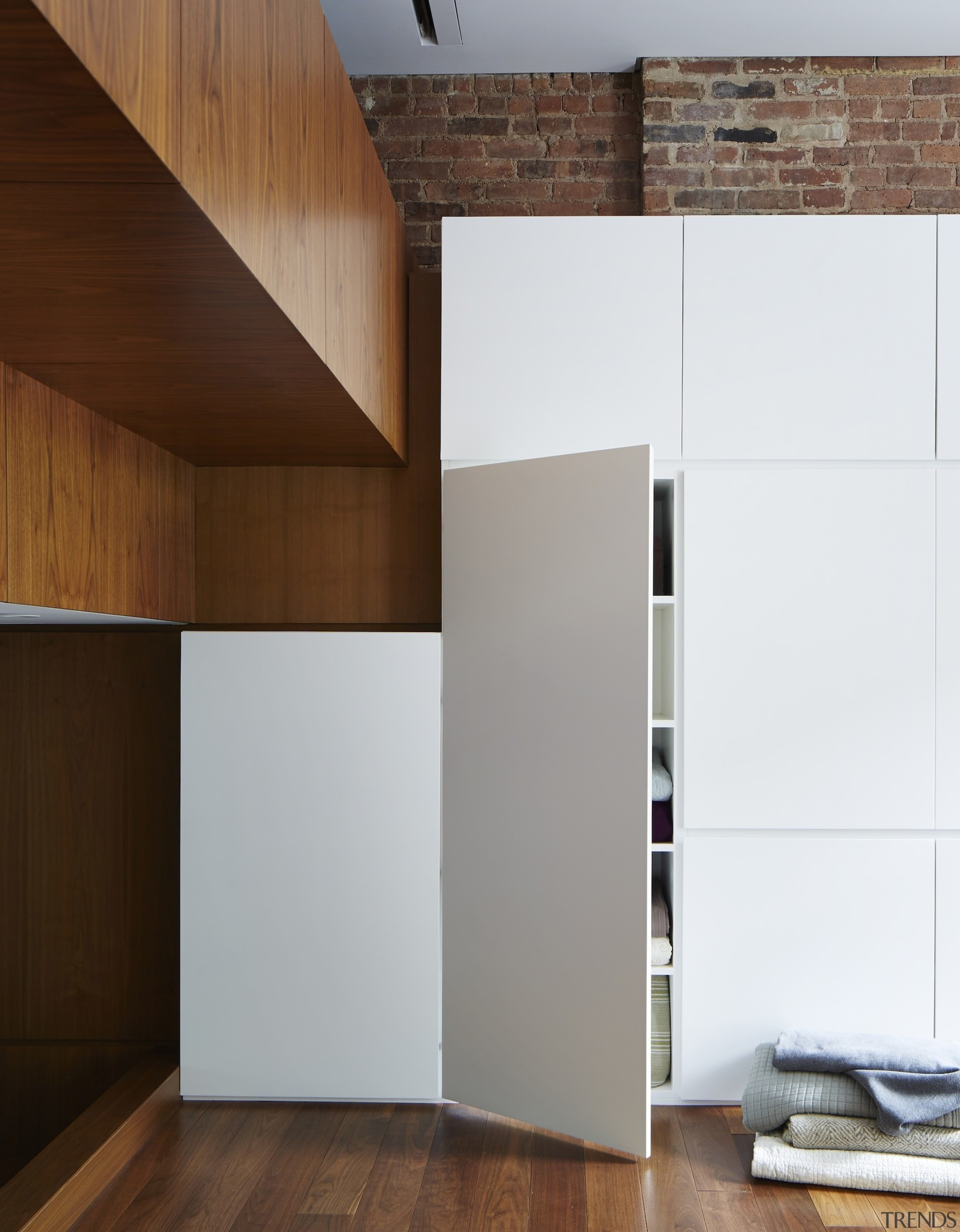 Storage abounds along this wall of the living architecture, floor, interior design, plywood, product design, wall, wood, white, brown