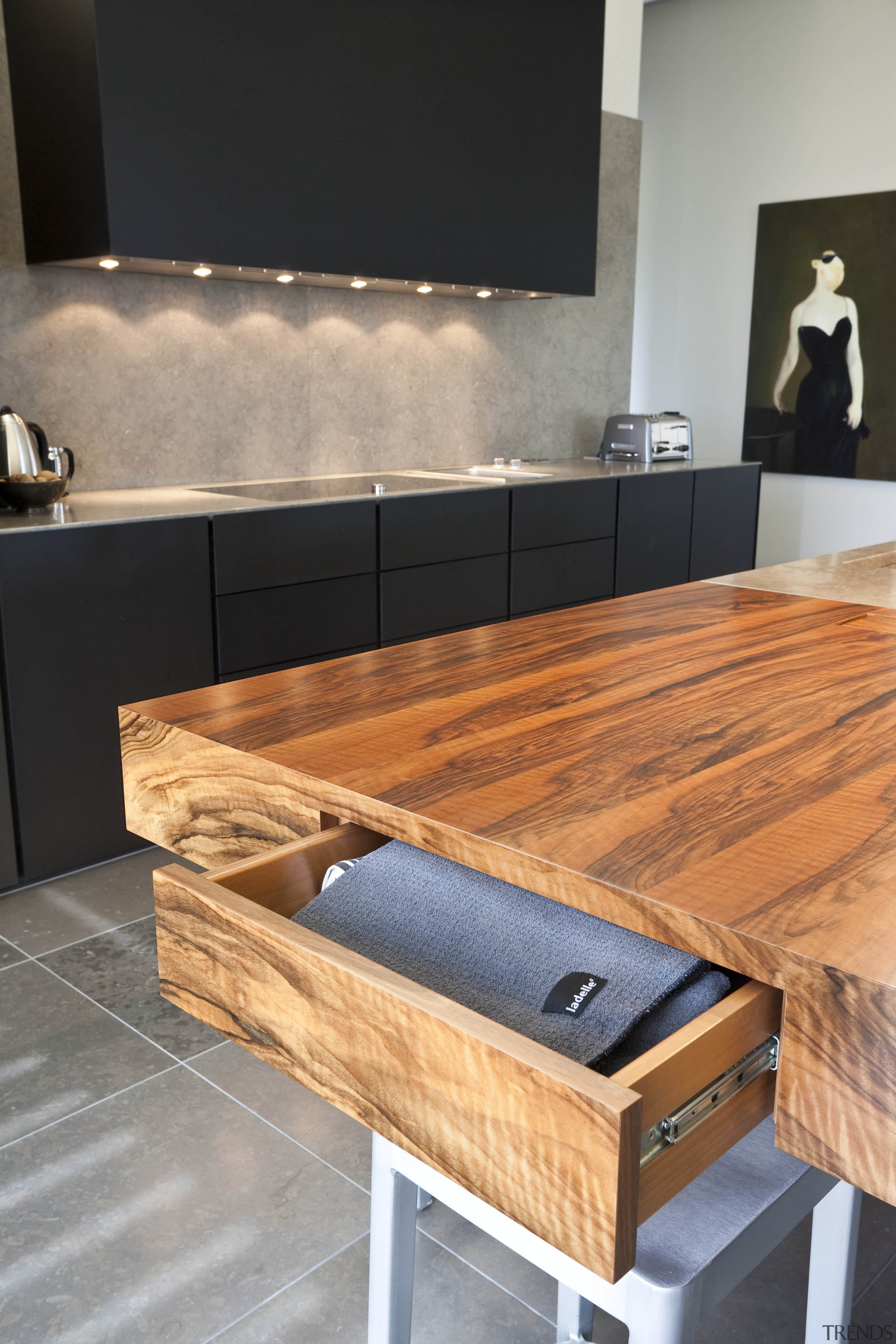 View of a contemporary kitchen which features island, countertop, floor, flooring, furniture, hardwood, interior design, product design, table, wood, wood flooring, wood stain, gray, black, orange