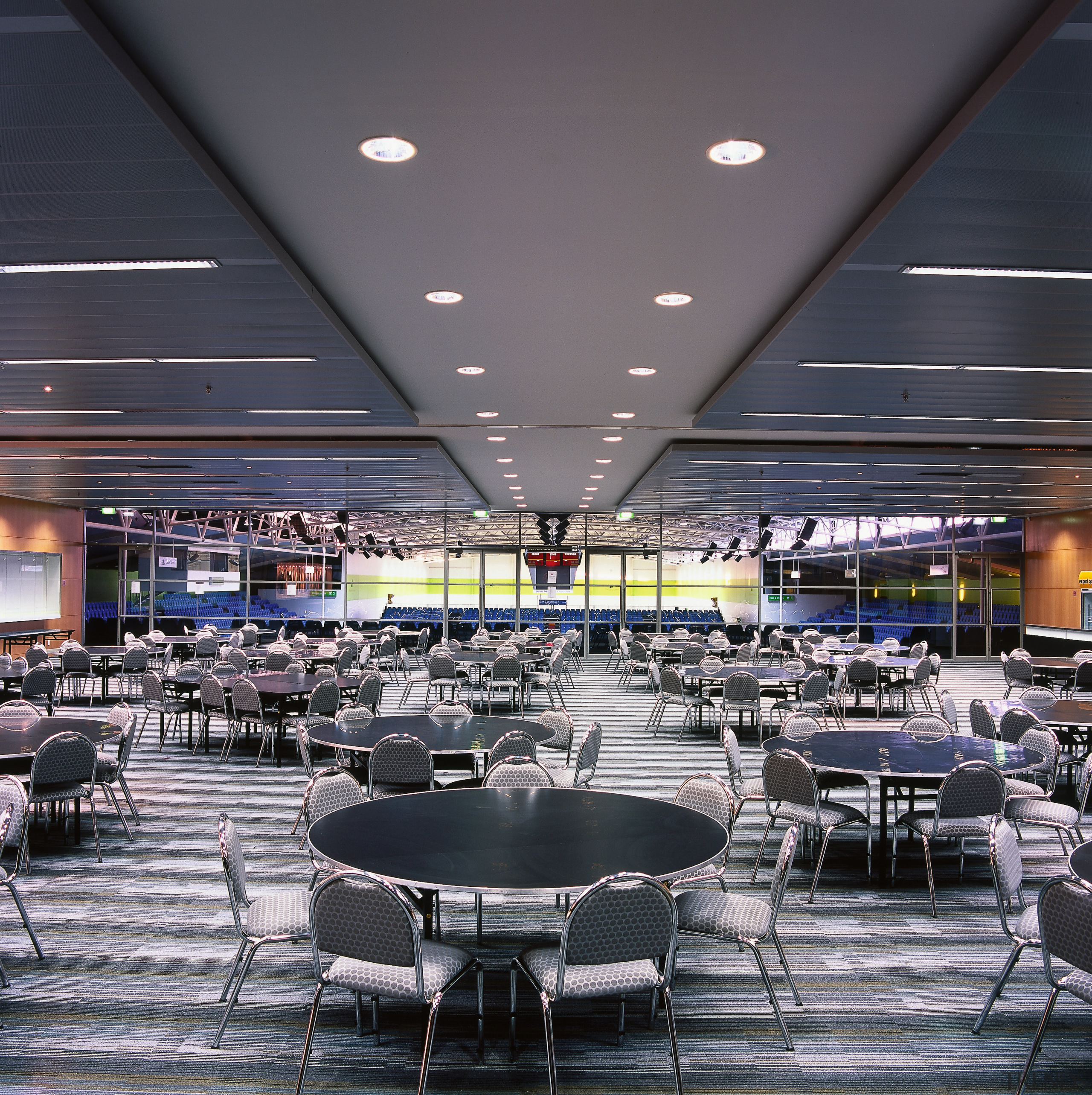 Seating area in stadium with round tables, panels cafeteria, ceiling, food court, interior design, restaurant, black, gray