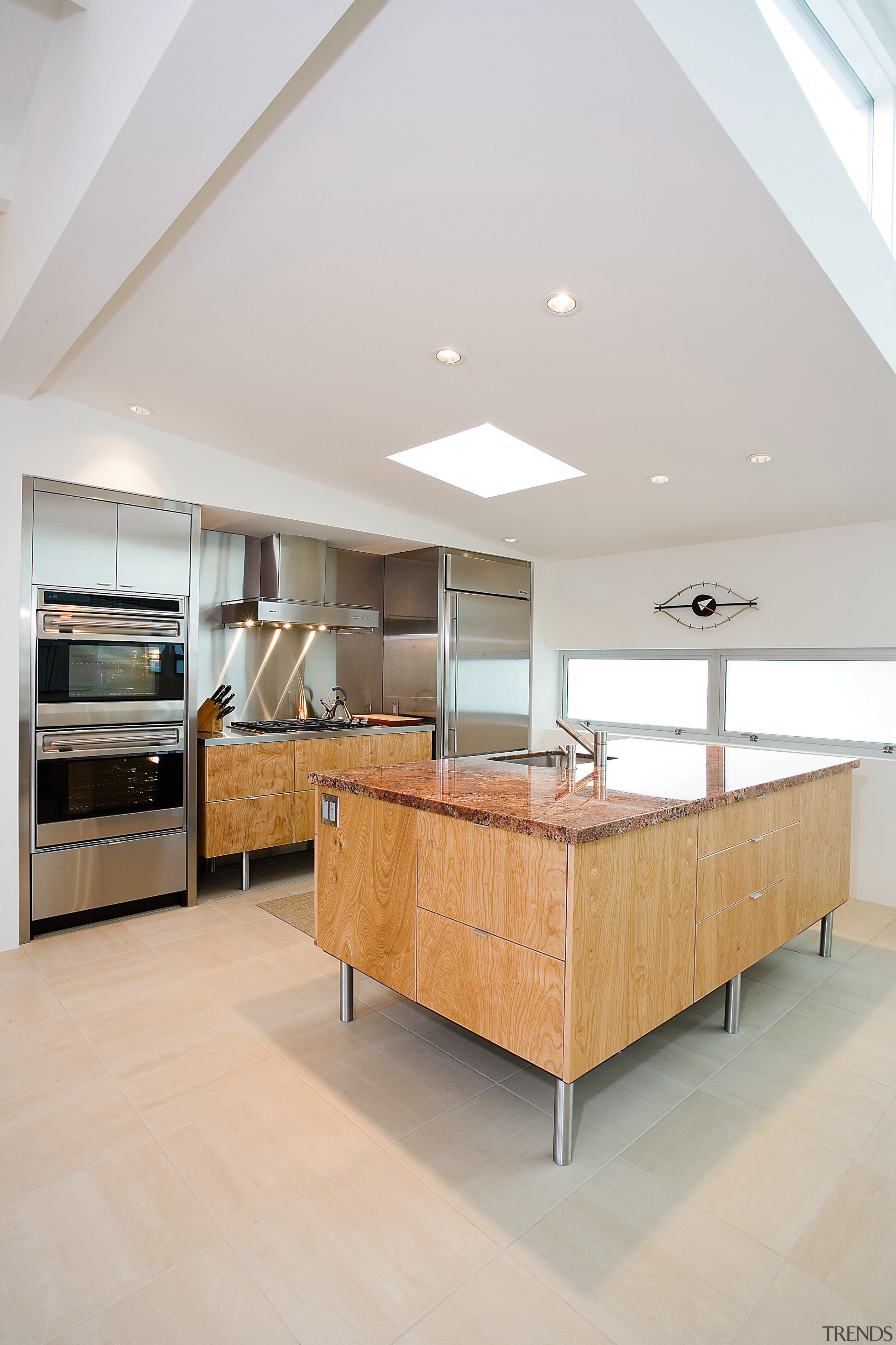 view of the kitchen featuring red birch cabinets, architecture, ceiling, countertop, daylighting, floor, flooring, furniture, hardwood, house, interior design, interior designer, kitchen, laminate flooring, living room, room, tile, wood, wood flooring, gray