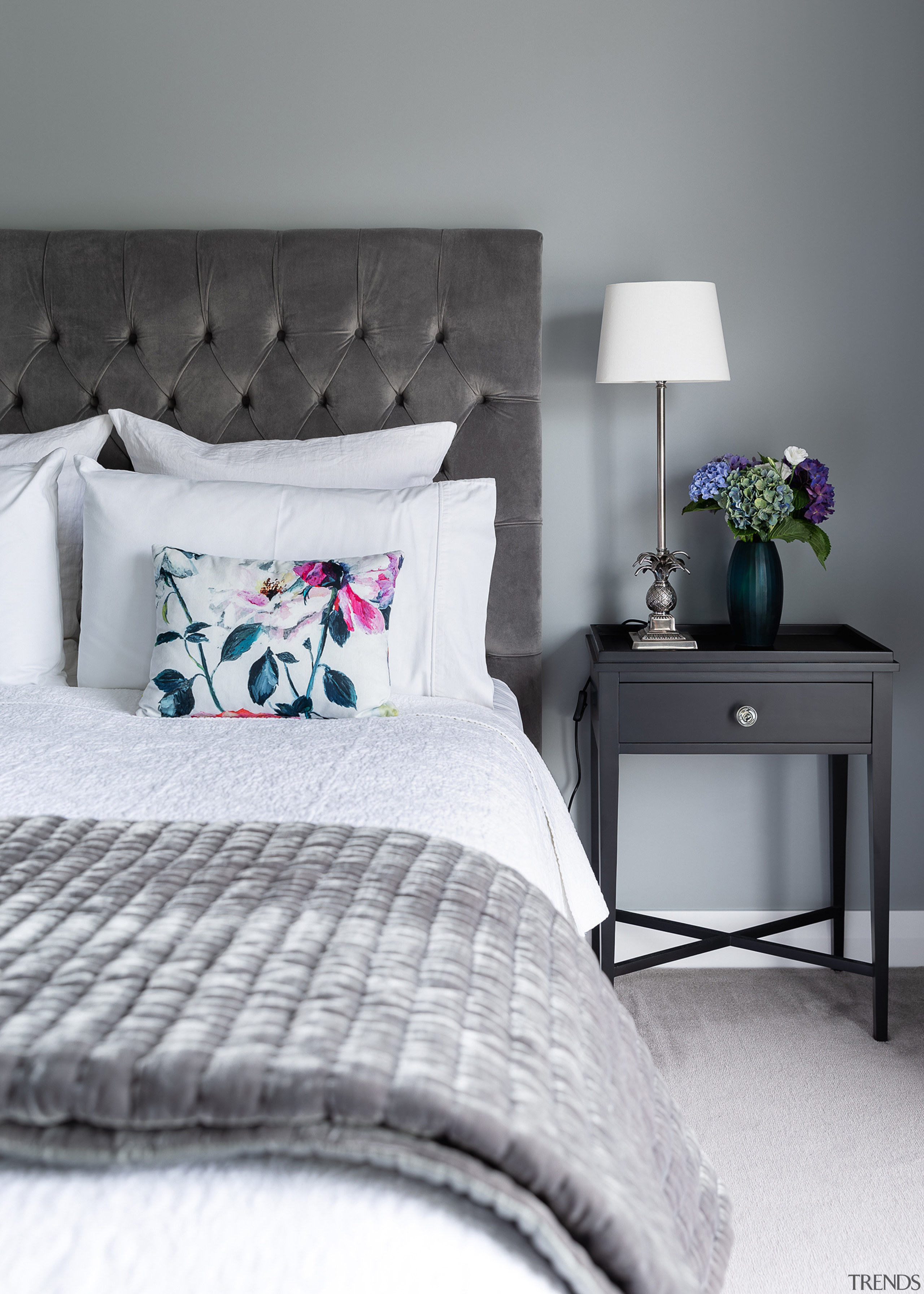 A padded headboard and elegant side table add 