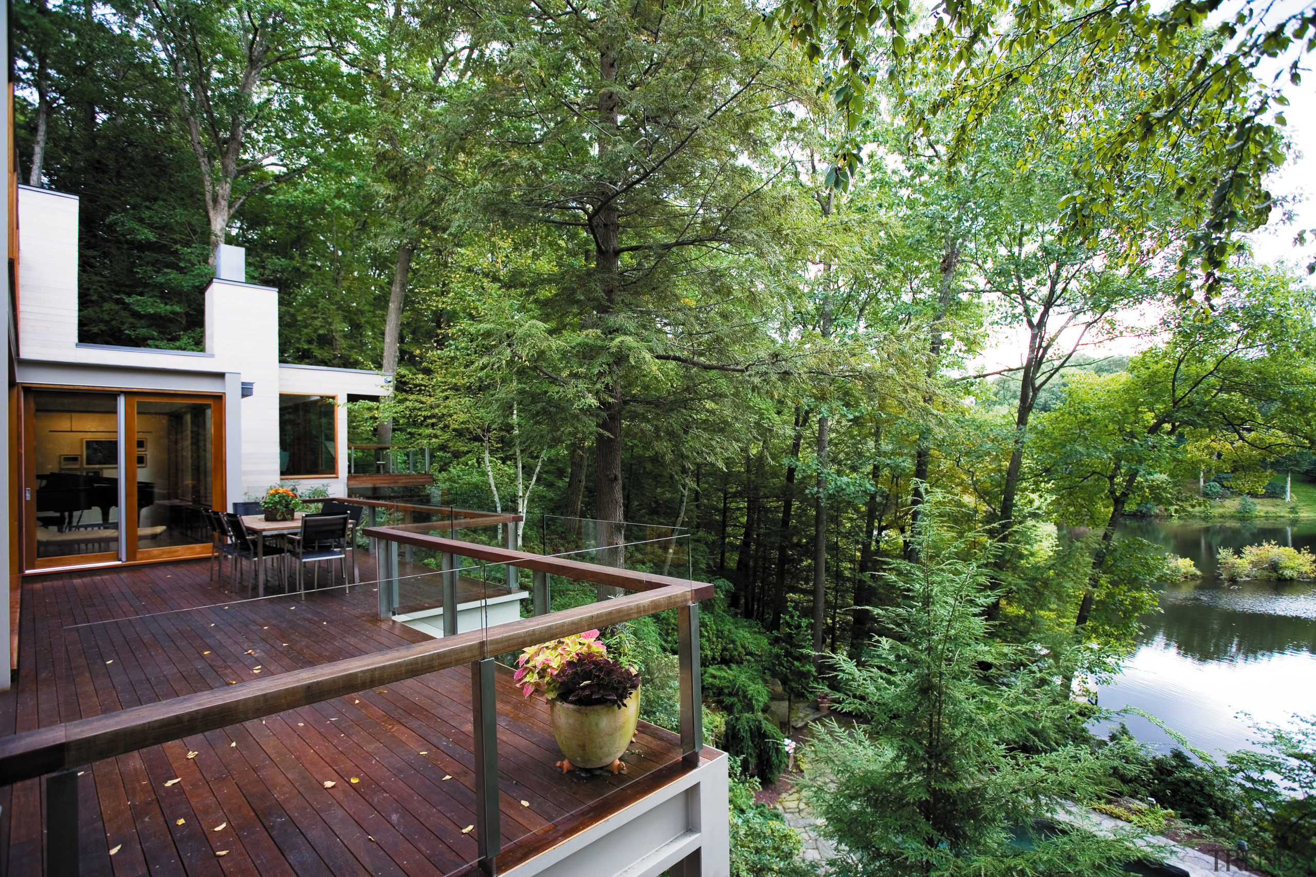 view of the entertaining deck area of this cottage, home, house, outdoor structure, plant, property, real estate, reflection, tree, water, green