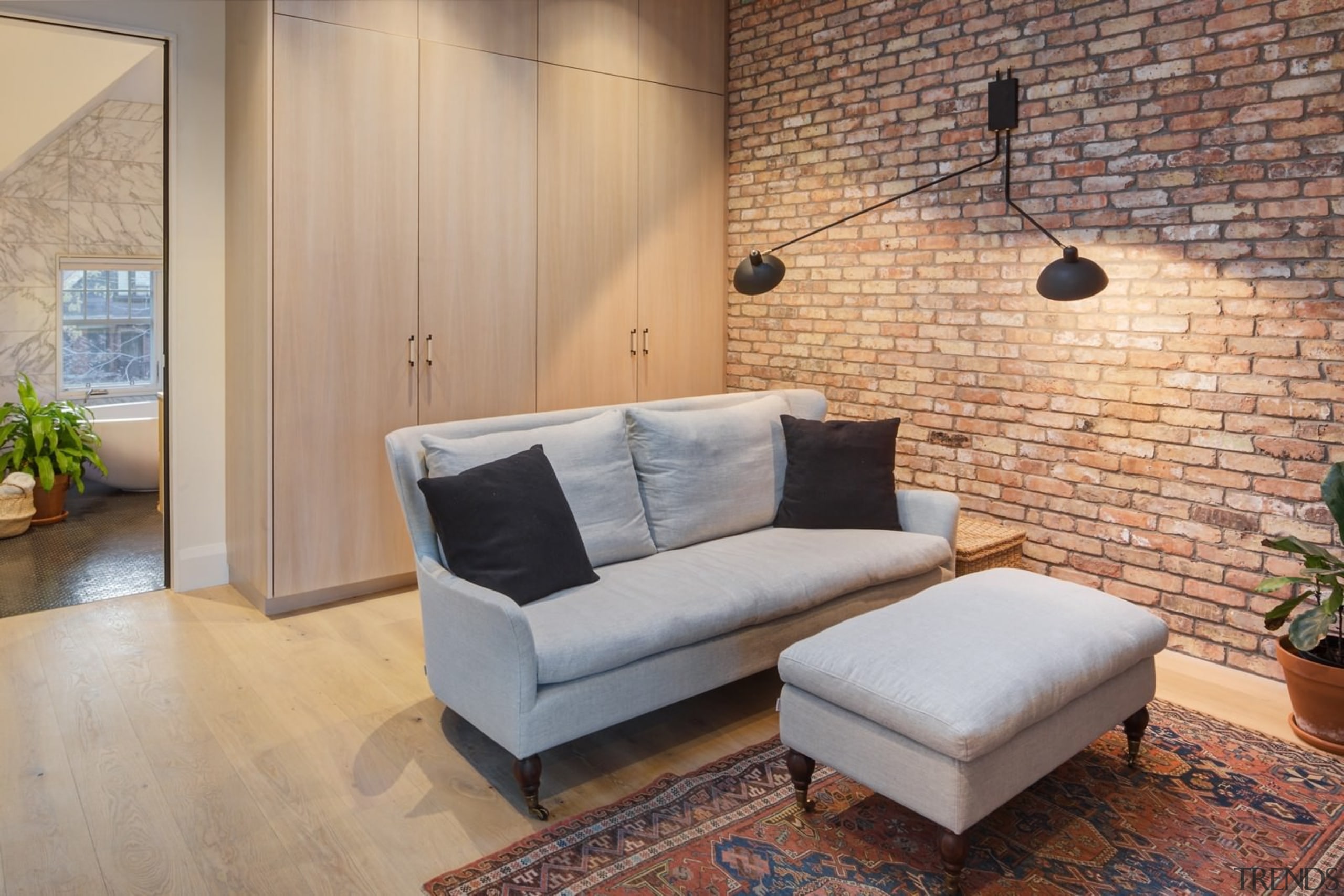 Another view of the brick feature wall and ceiling, couch, floor, flooring, furniture, hardwood, home, interior design, living room, loft, property, real estate, room, wall, wood, wood flooring, gray, orange