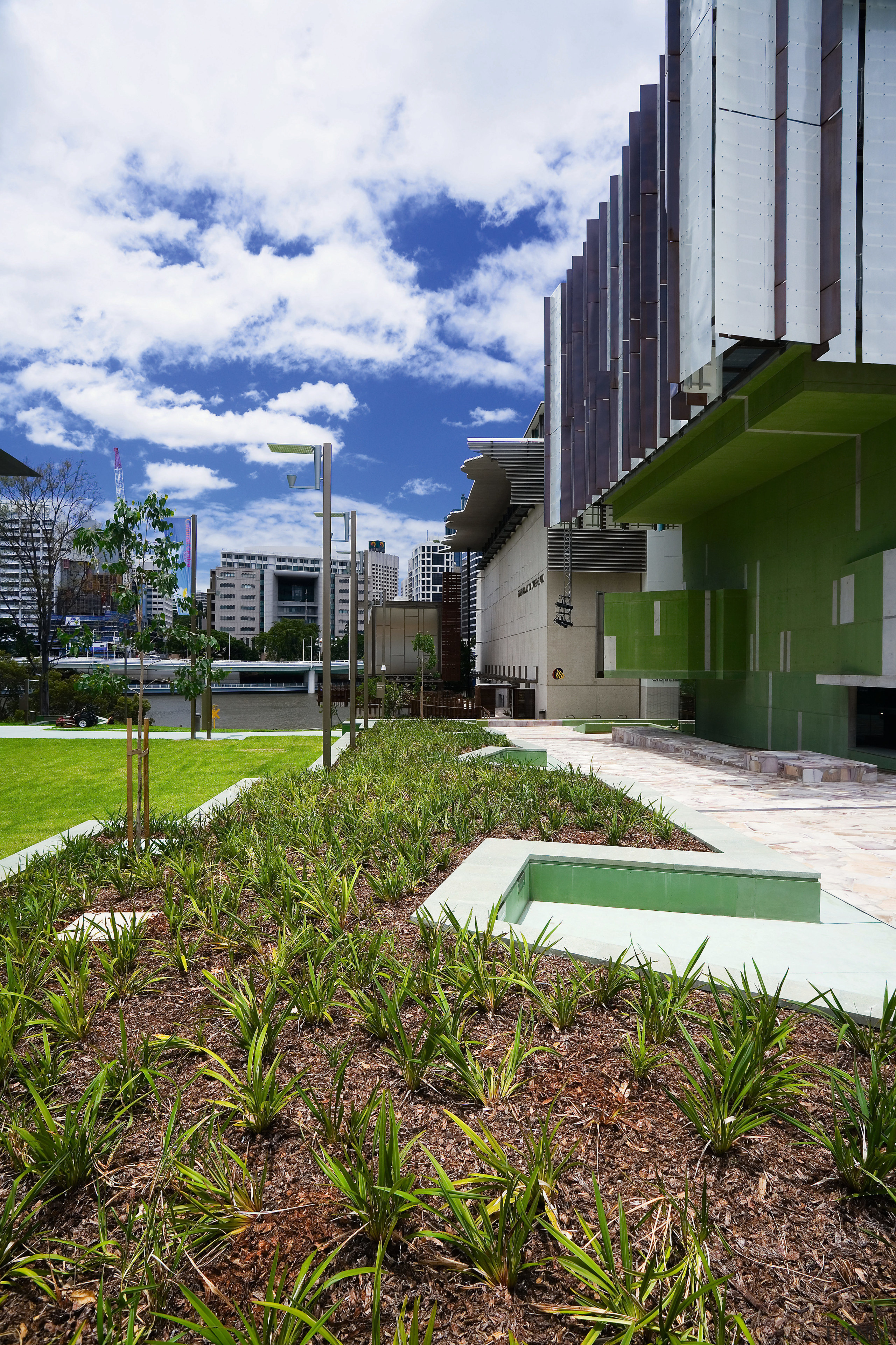 A view of some landscaping by Dig It architecture, building, city, condominium, daytime, estate, grass, home, house, landscape, plant, real estate, residential area, sky, tree, urban area, white, brown