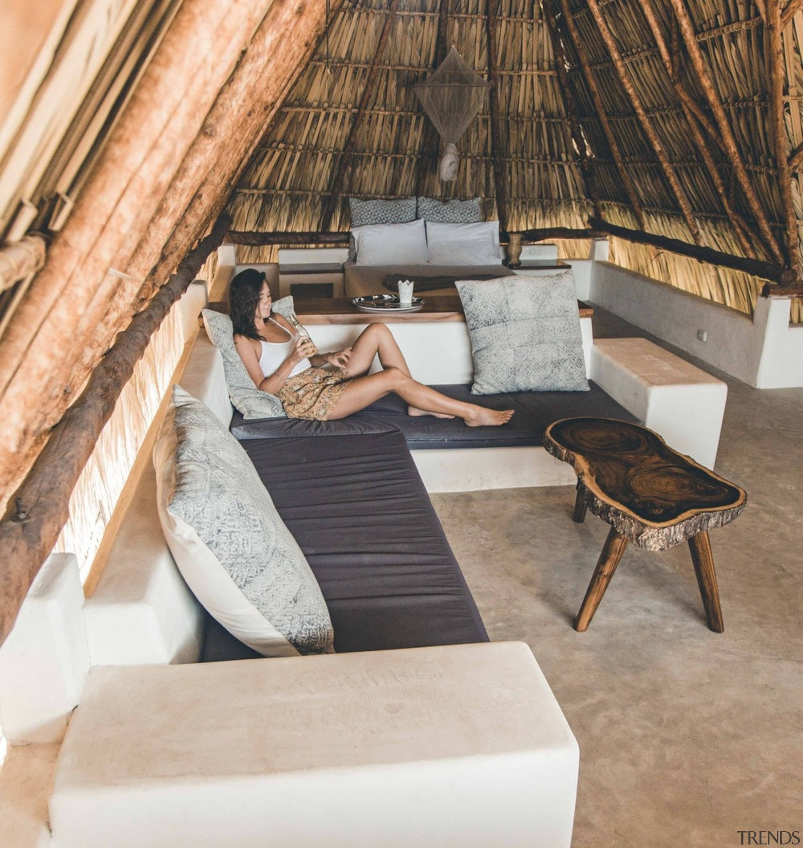 The locally inspired thatched palm roof dominating the comfort, floor, furniture, house, interior design, leg, leisure, room, table, tree, vacation, gray