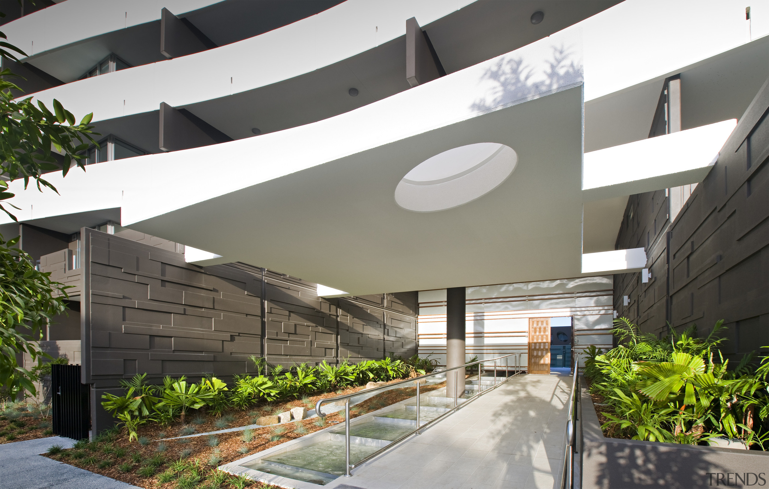Exterior view of the Flow Apartments which sit architecture, condominium, corporate headquarters, courtyard, daylighting, mixed use, real estate, gray, white