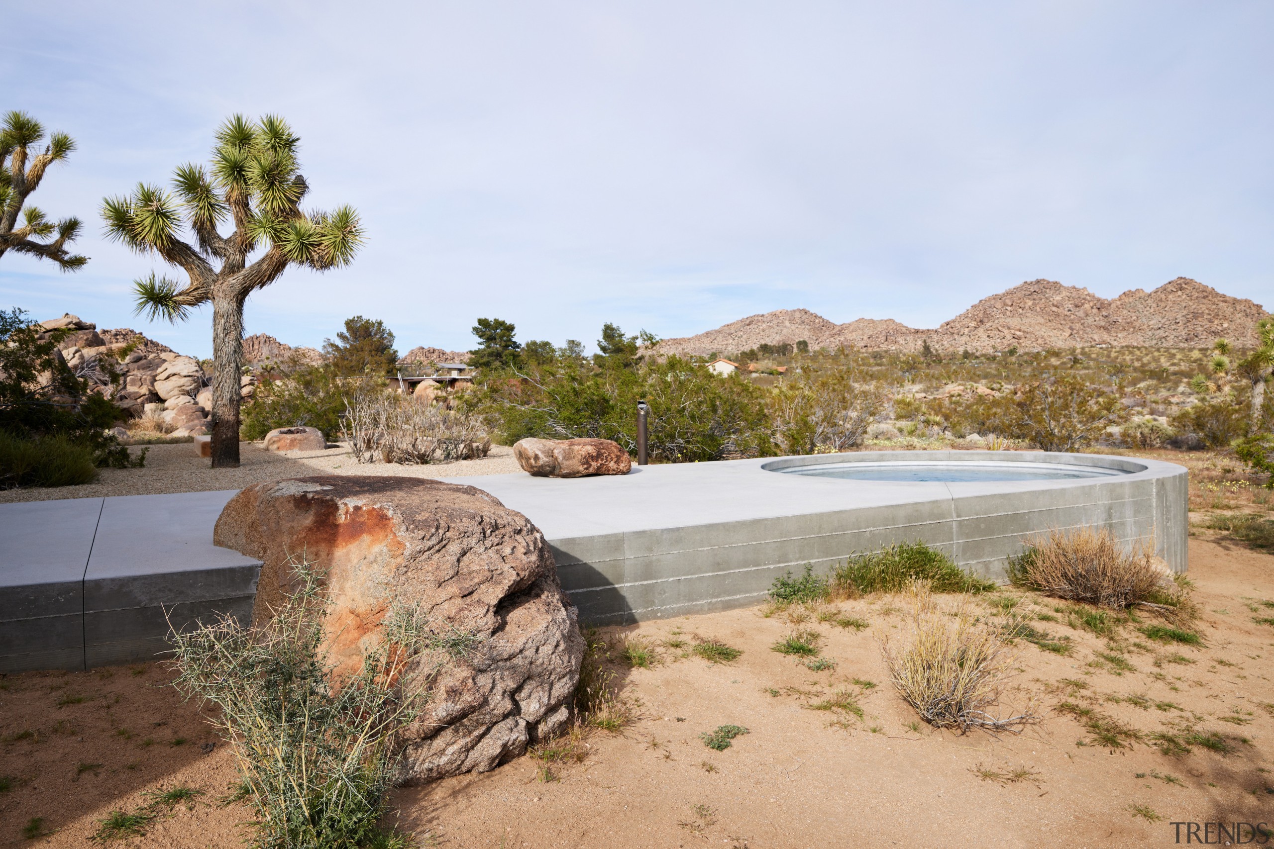 Over-lying rocks make the concrete walkway and pool 