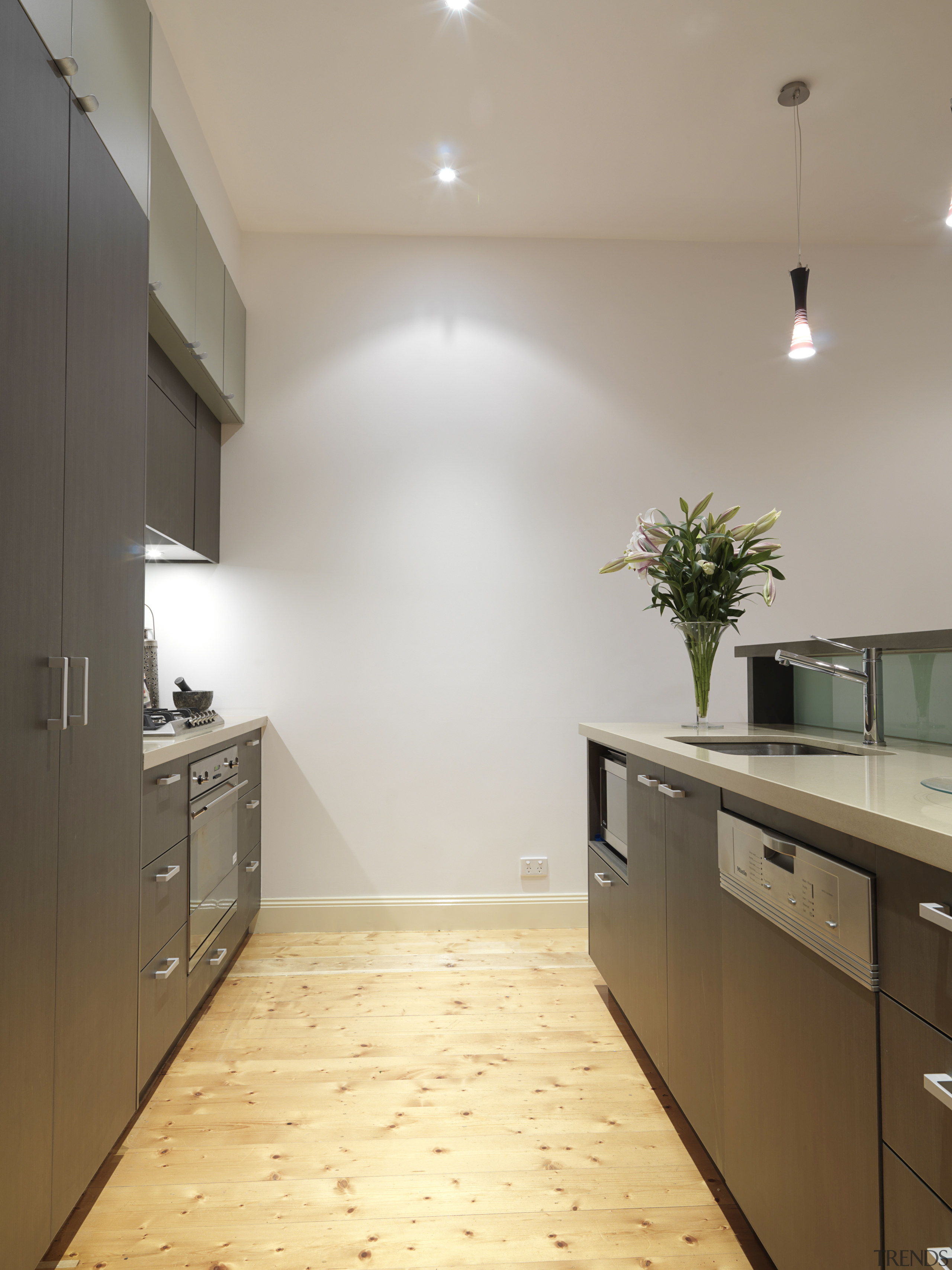 View of a kitchen featuring island, dark brown architecture, cabinetry, ceiling, countertop, daylighting, floor, flooring, hardwood, home, house, interior design, kitchen, laminate flooring, property, real estate, room, tile, wall, wood flooring, gray