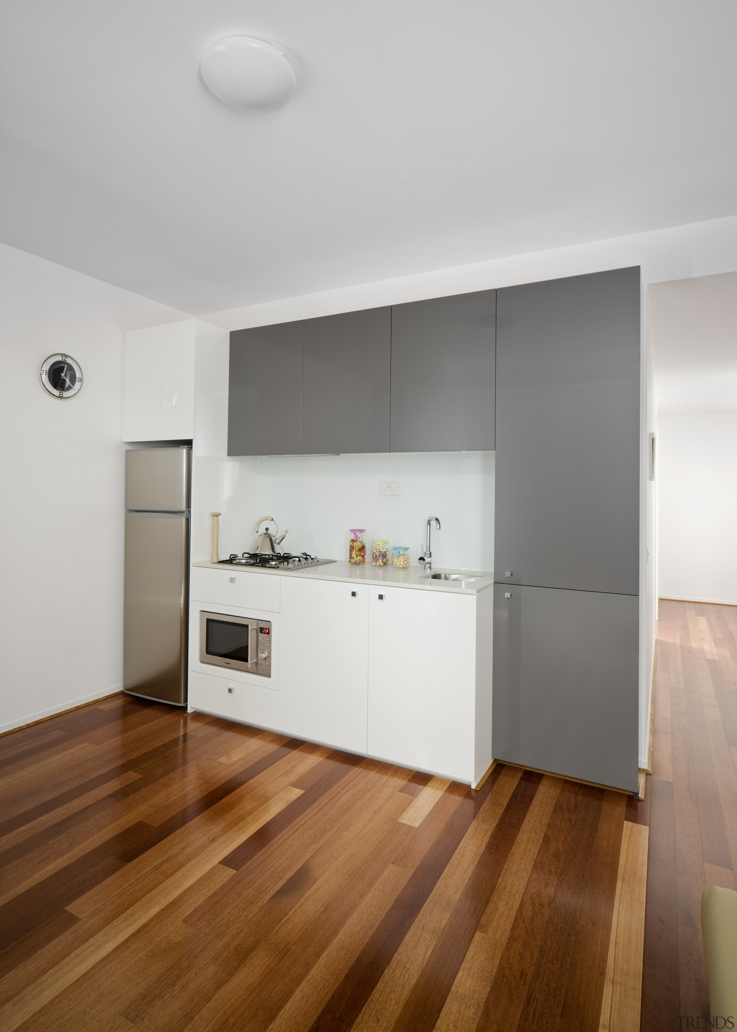 View of the kitchen area inside a student apartment, ceiling, floor, flooring, hardwood, house, interior design, laminate flooring, loft, real estate, room, wall, wood, wood flooring, gray