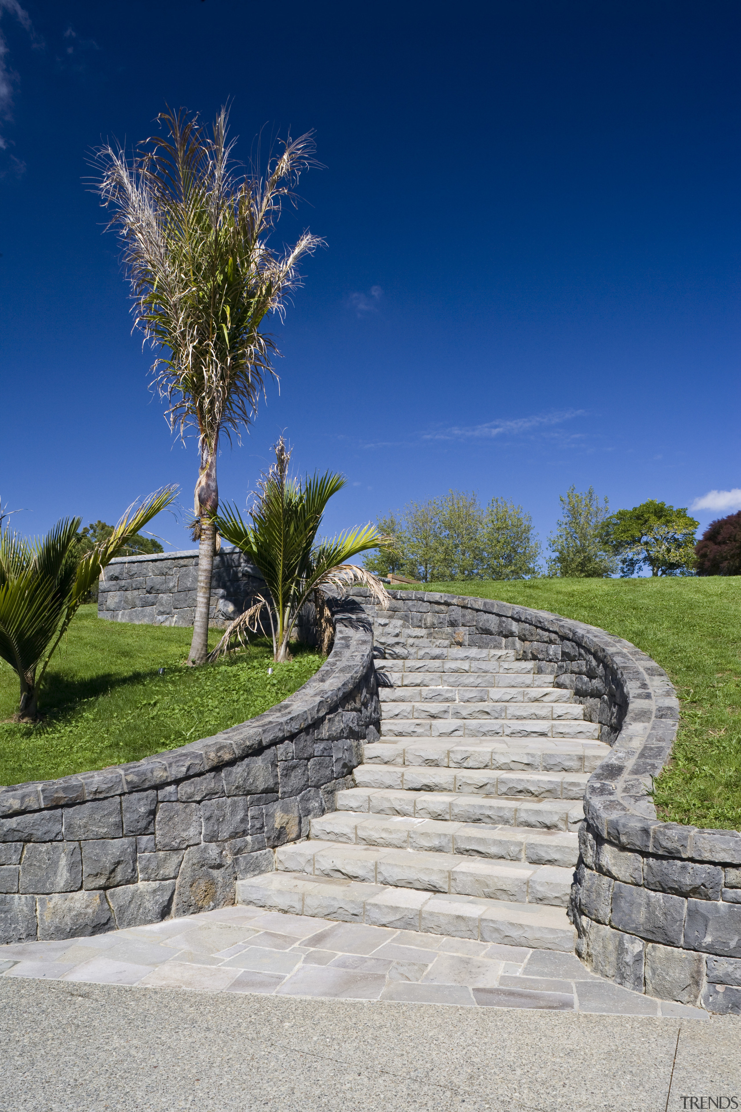 Image of stone walls which have been built estate, grass, landscape, landscaping, path, sky, tree, walkway, wall, blue, gray