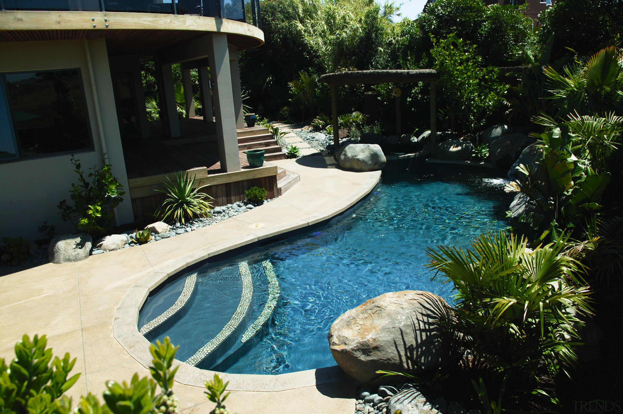 Landscaped swimming pool area with paving, boulders, plants backyard, estate, landscape, landscaping, leisure, outdoor structure, plant, property, real estate, resort, swimming pool, water, water feature, yard, black